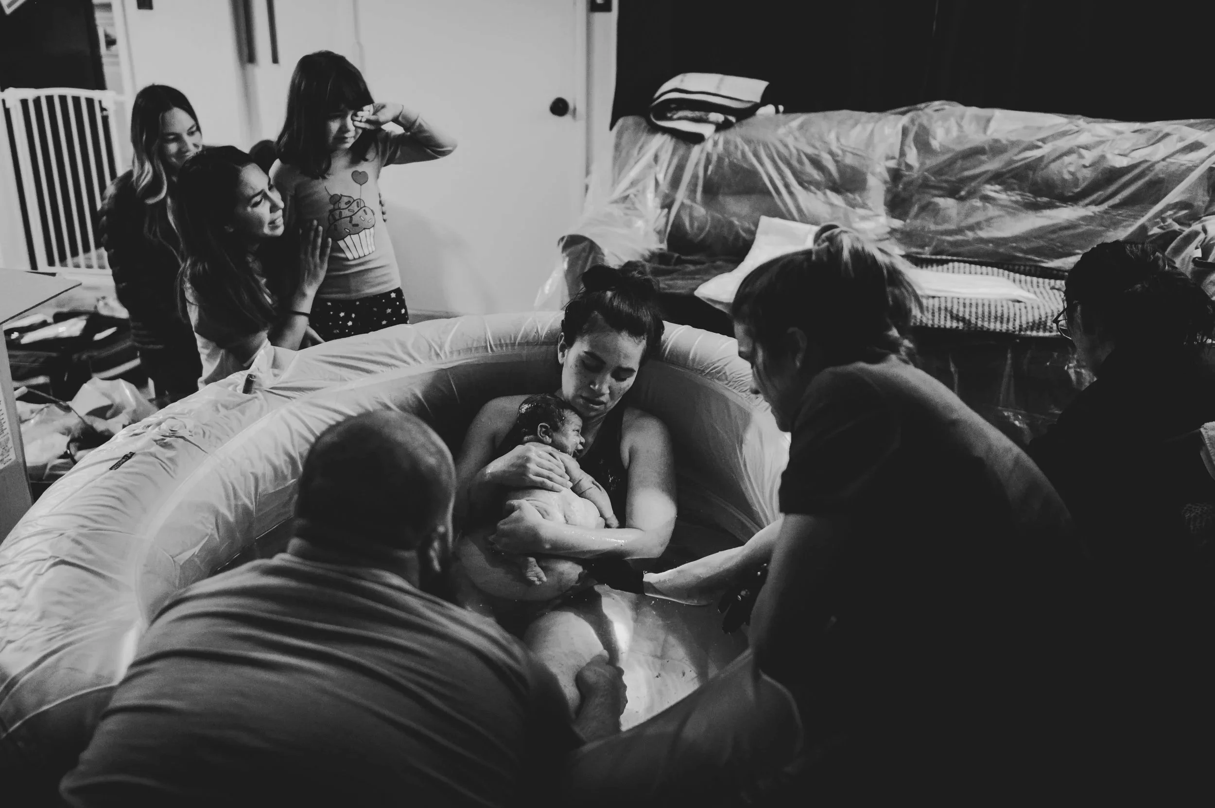 Big sister and auntie in tears as they just witnessed a beautiful baby being born at home in the water. Whittier, California. Alaina Nunez
