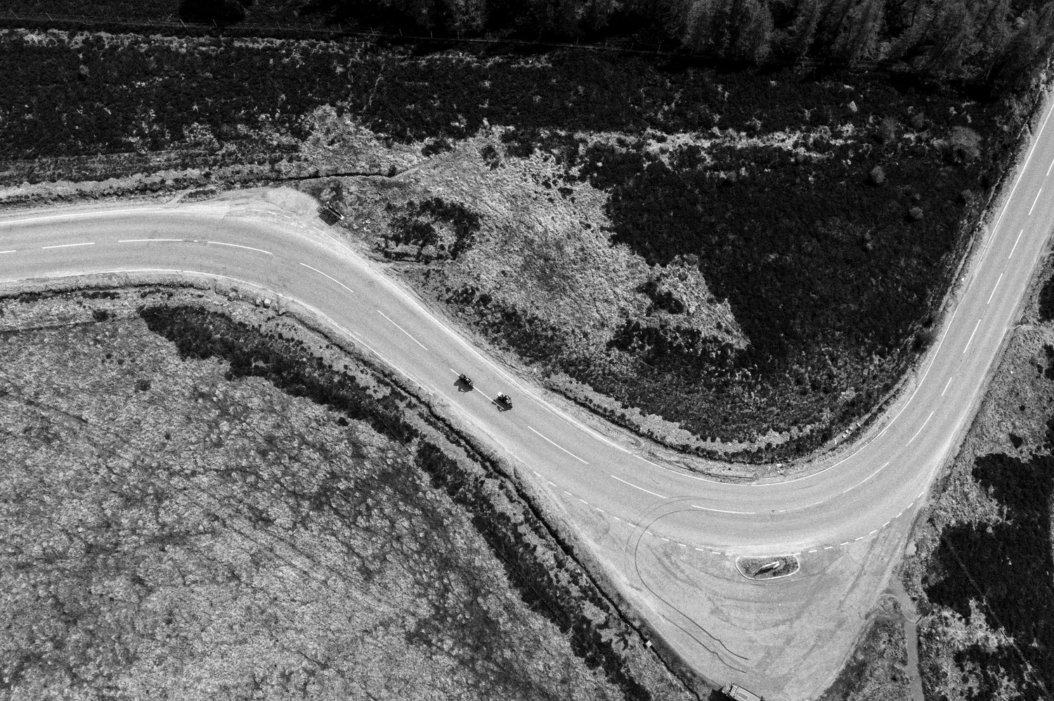 Riders on a remote winding moorland road from above