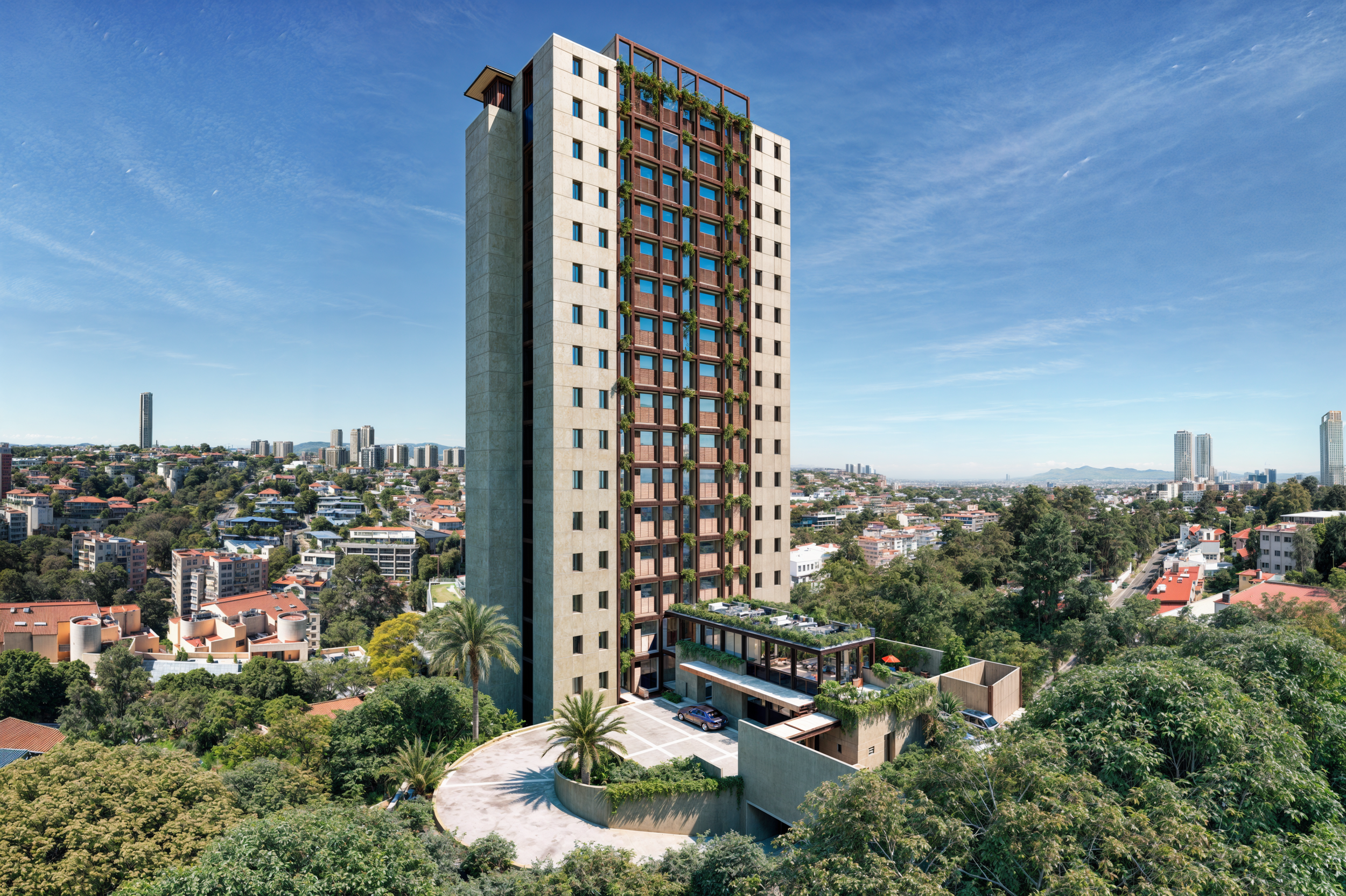 Edificio alto en zona urbana con muchas ventanas y plantas en la fachada, rodeado de árboles y casas, con ciudad y montañas al fondo, en un día soleado con cielo despejado.