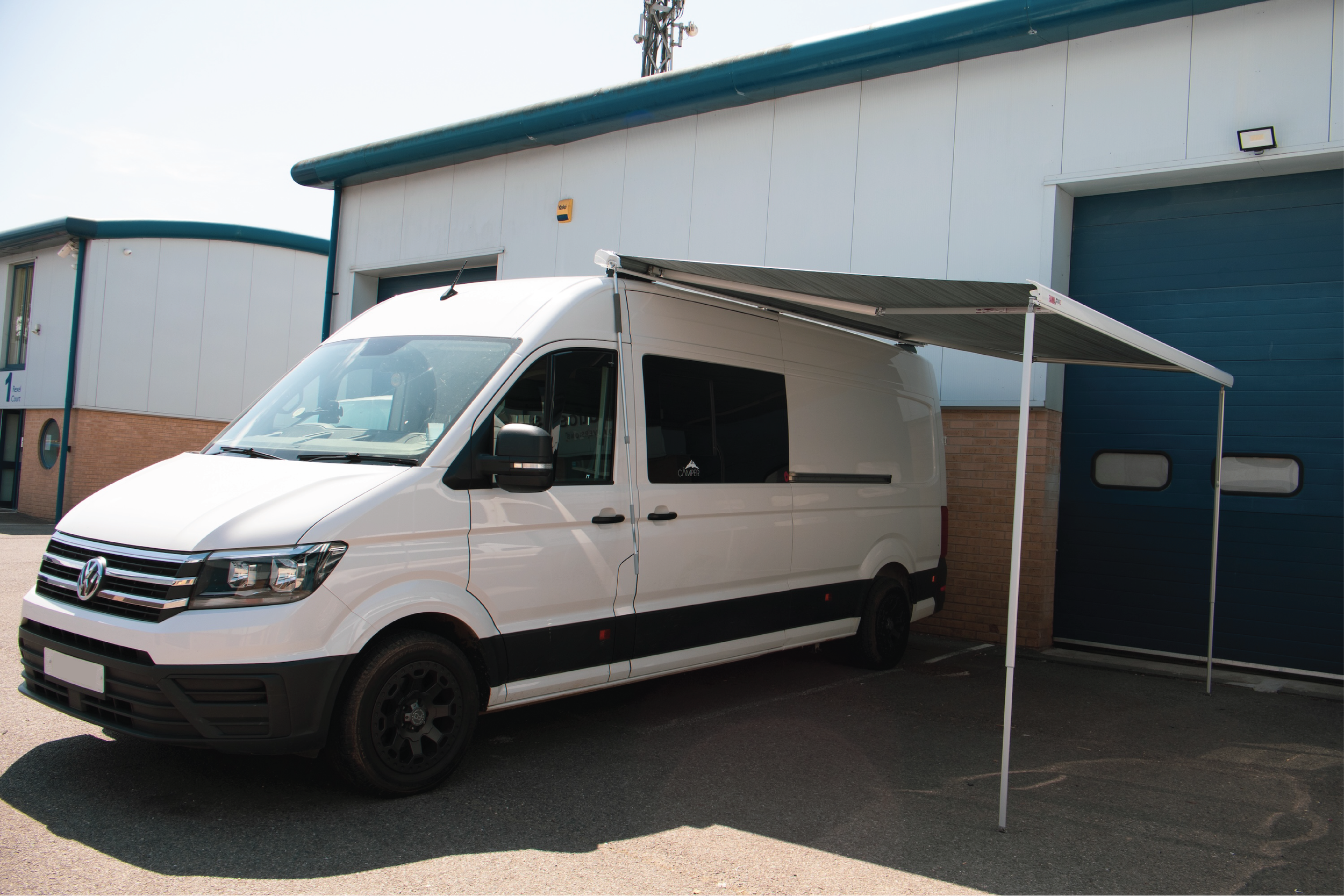 White Albatross Conversions VW Crafter off-grid custom van conversion with awning parked outside our Poole workshop.
