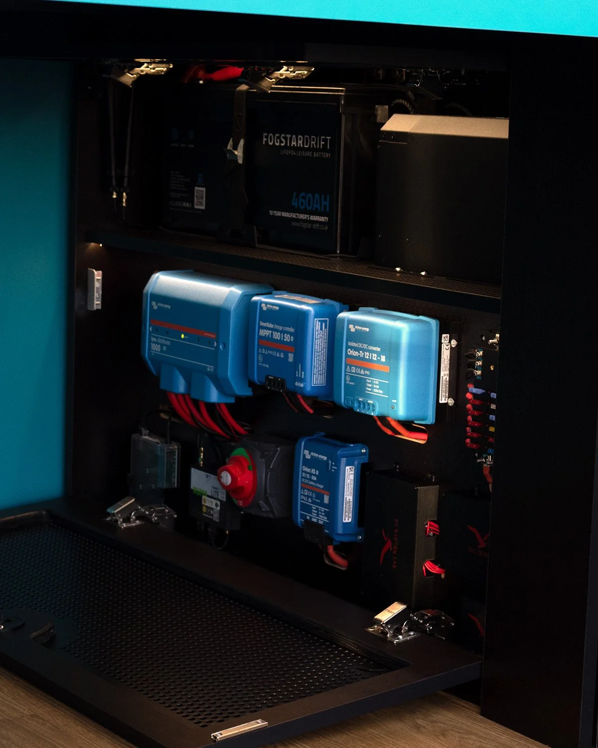 Fully off-grid electrical system in the Albatross Wander Edition campervan, with 460AH 12V lithium battery, 400W solar, 3000W inverter, and DC/AC chargers beneath rear seating