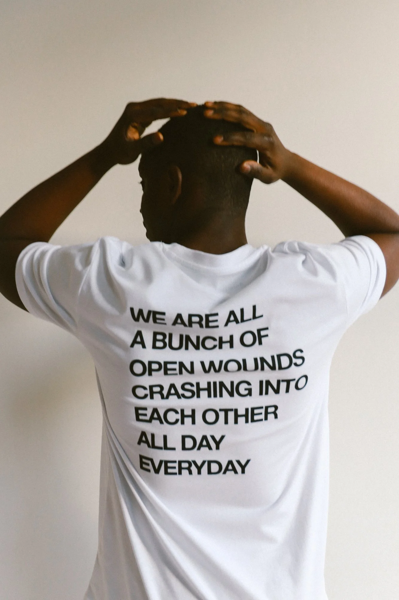 20260901_192_WEAREALLABUNCHOFOPENWOUNDSCRASHINGINTOEACHOTHERALLDAYEVERYDAY_WHITE_TSHIRT_ANNEBARLINCKHOFF.jpg