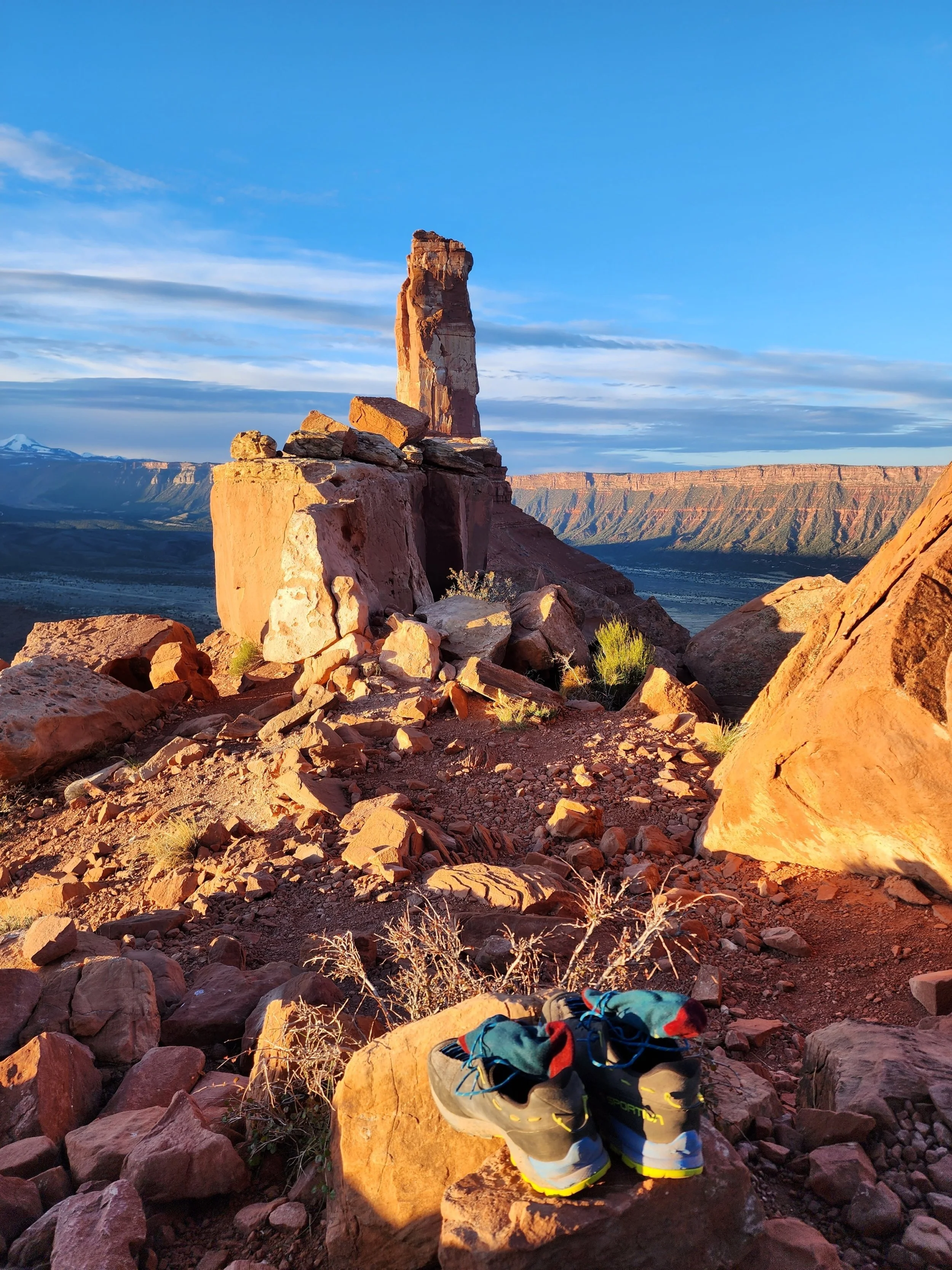 Socks woven into approach shoe laces with Castleton tower in the background during sunrise