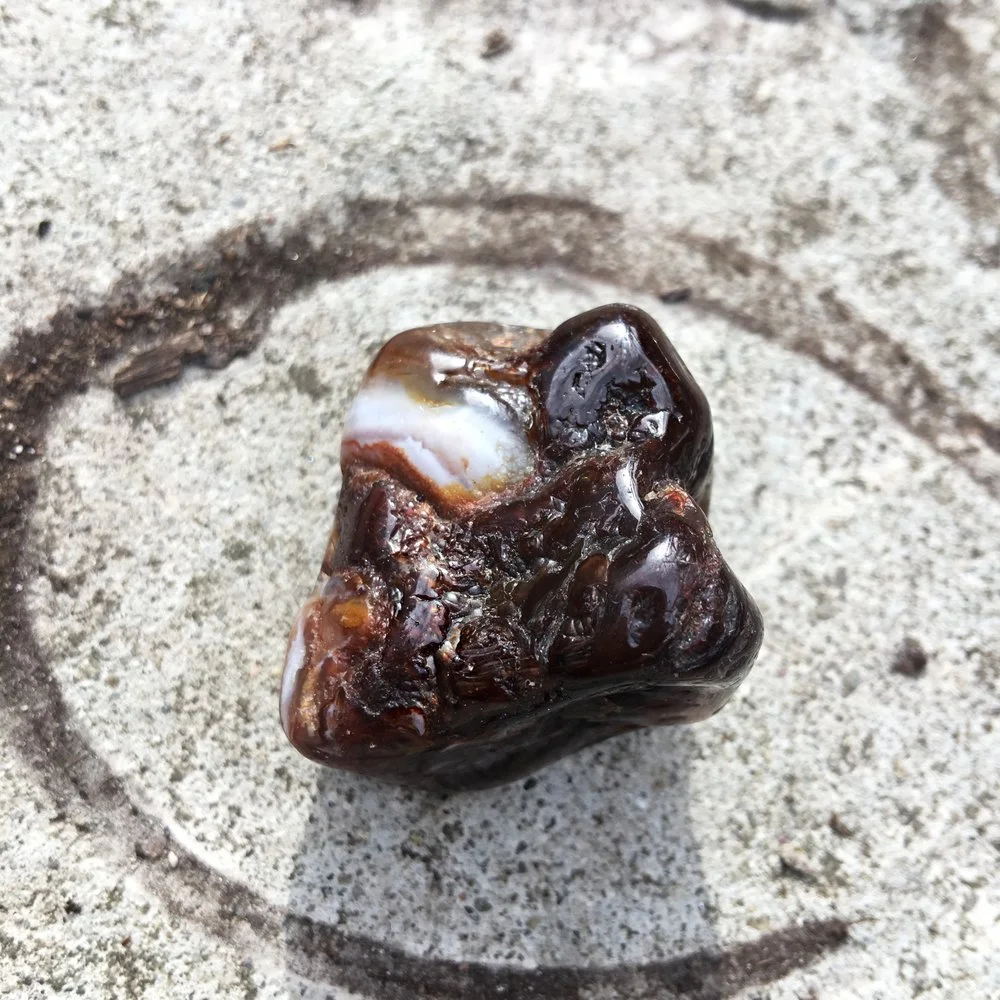 a fire agate stone with white banding and a brown color