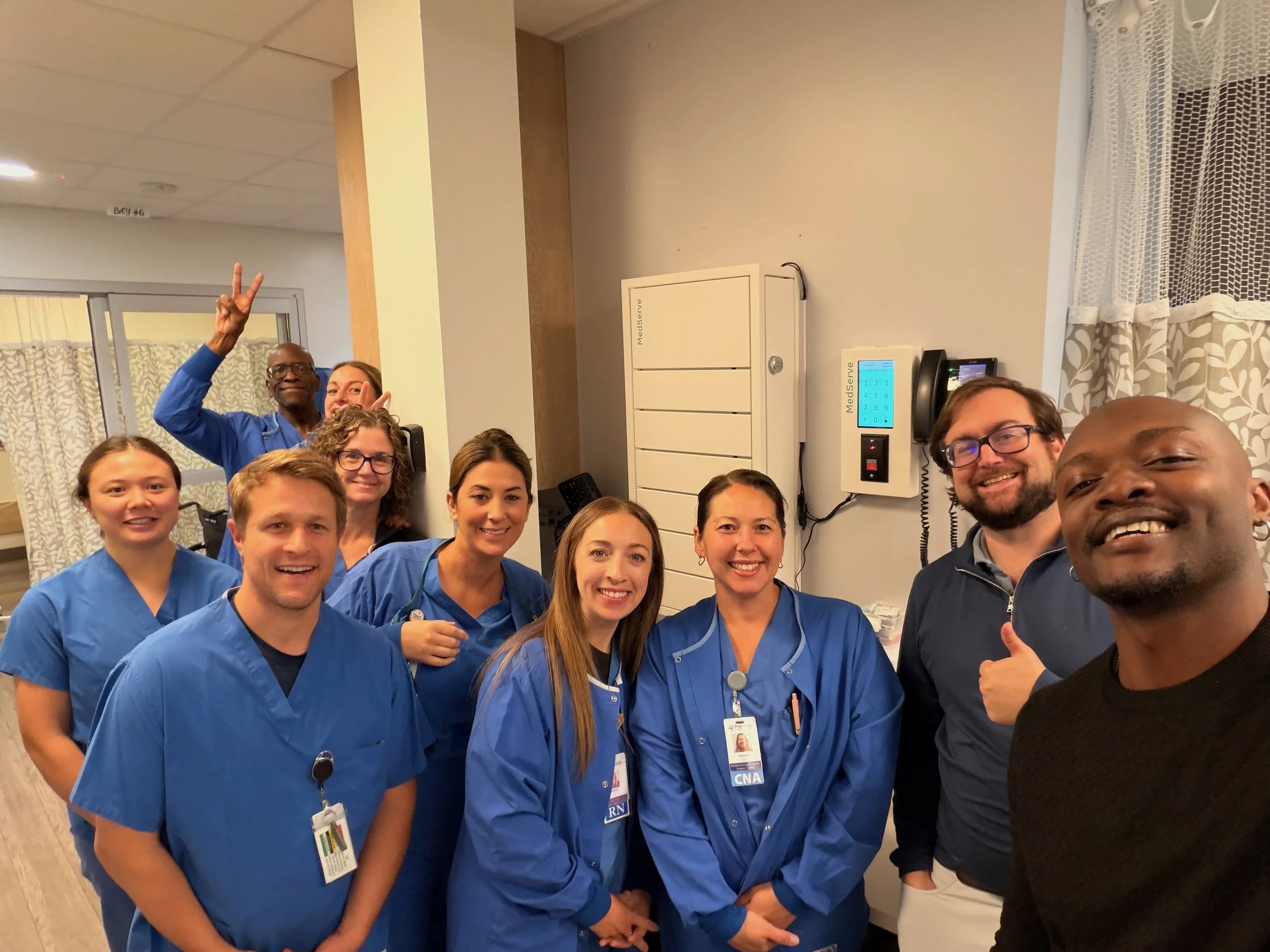 Two MedServe employees and a happy ASC staff, posing for a group photo in front of a MedServe Flex.