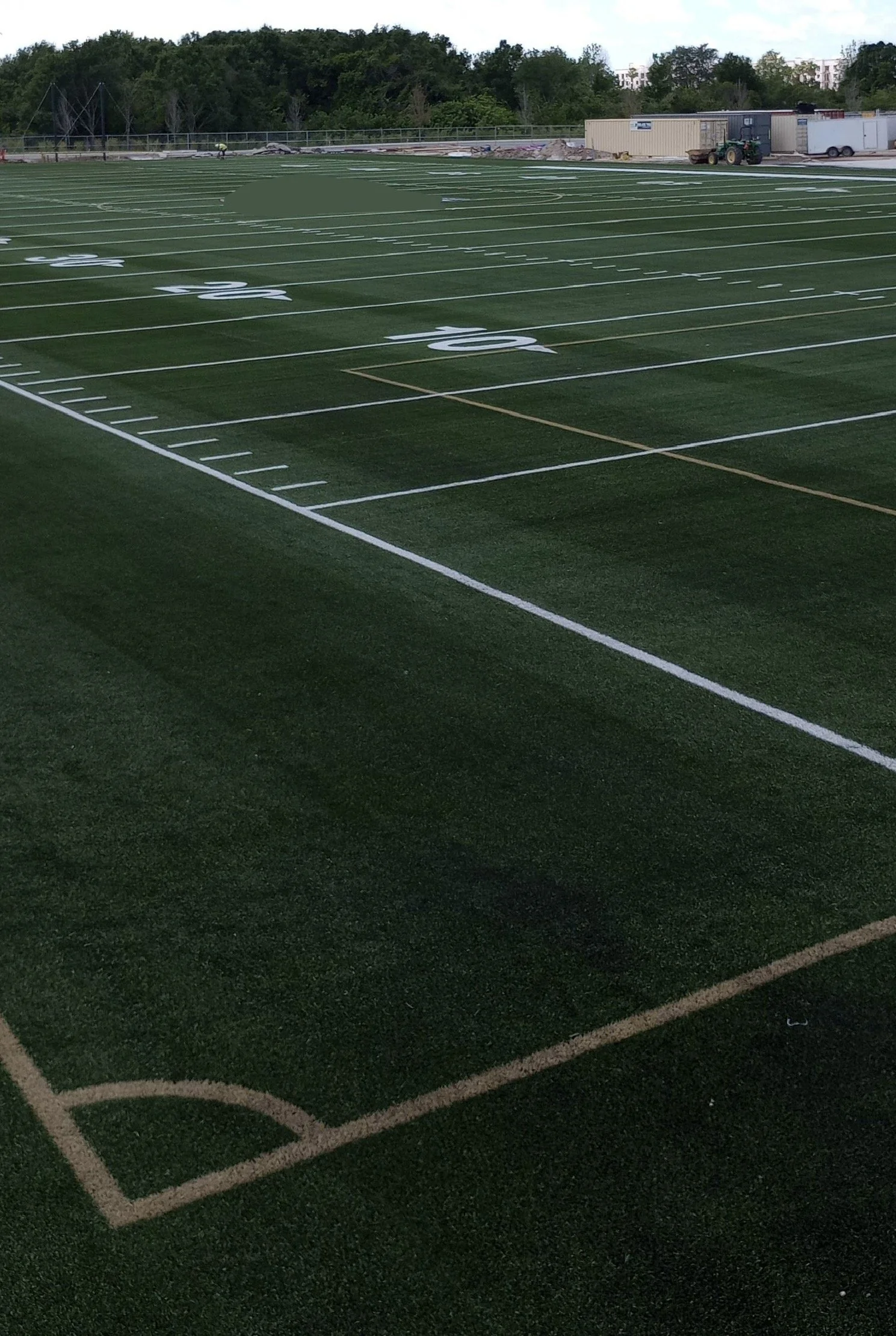 Empty football field with artificial turf and yard line markings