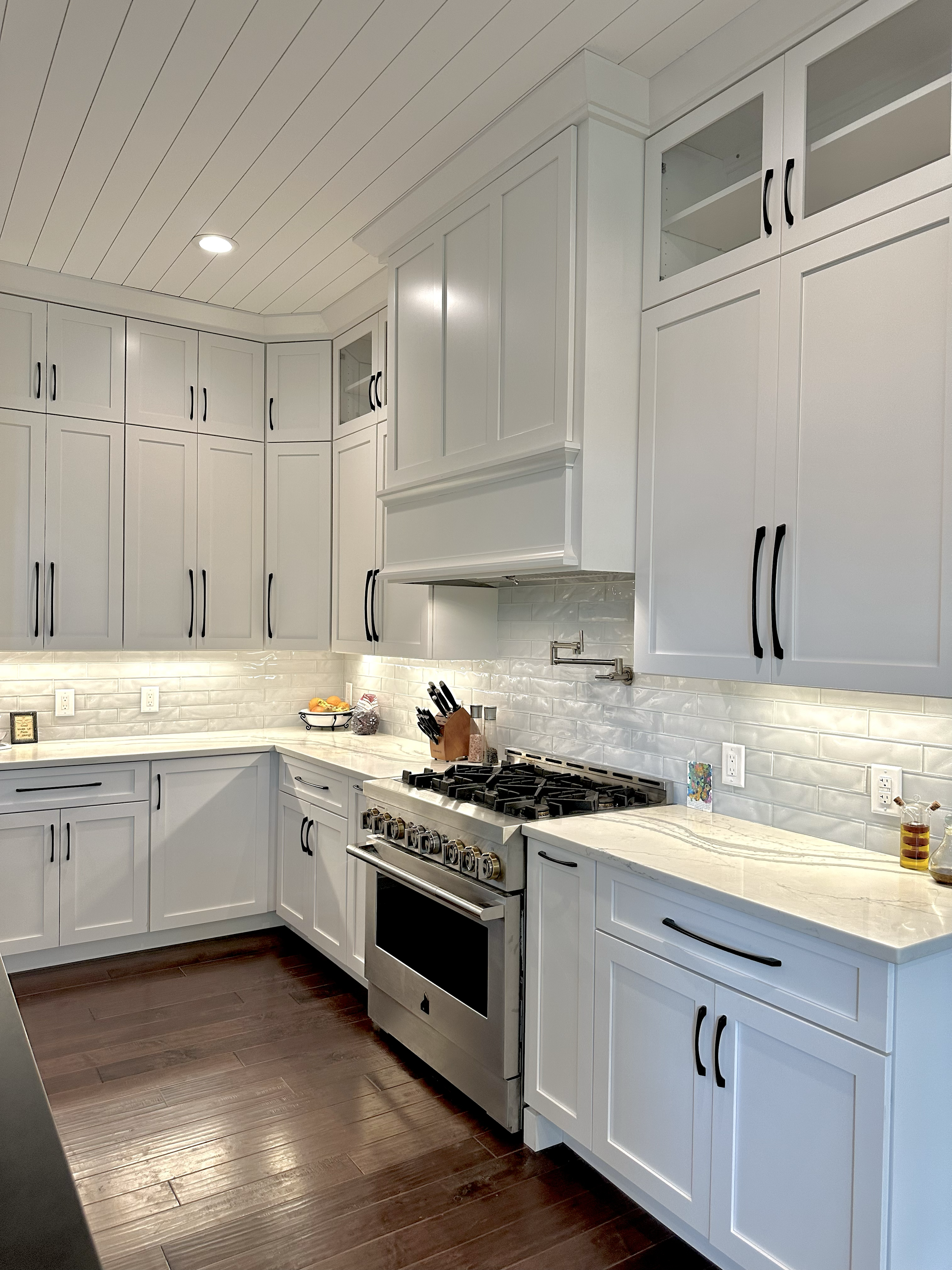 White perimeter cabinetry with continuous light stone counters