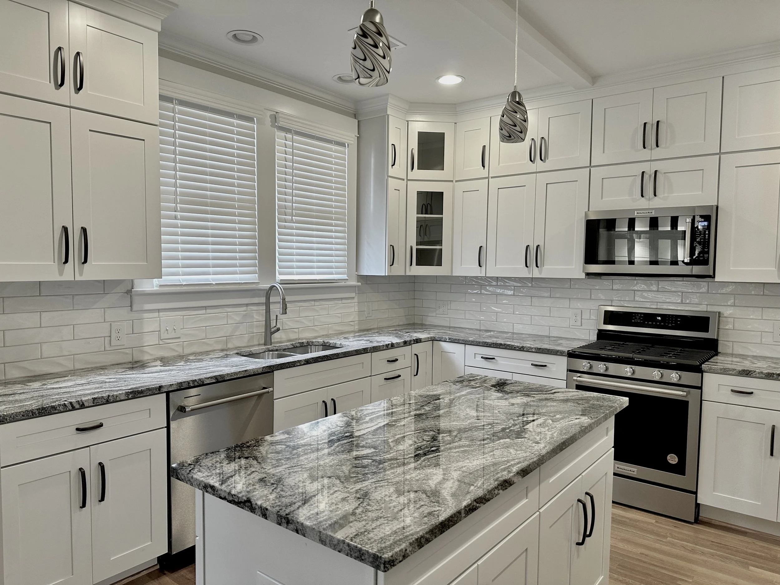 White kitchen with expressive patterned natural stone countertops