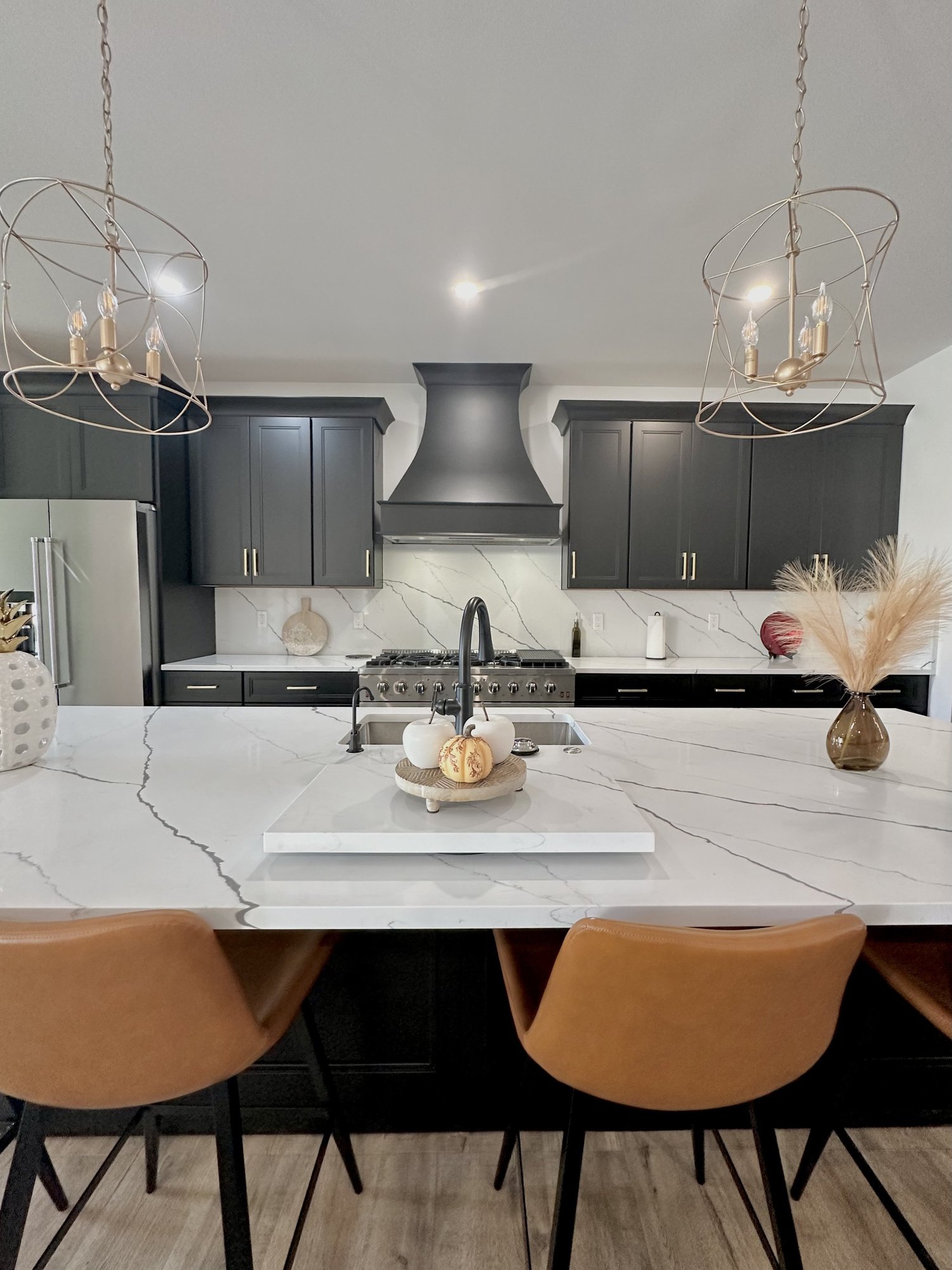 White veined countertop installed with dark kitchen cabinets by Sondos Stone