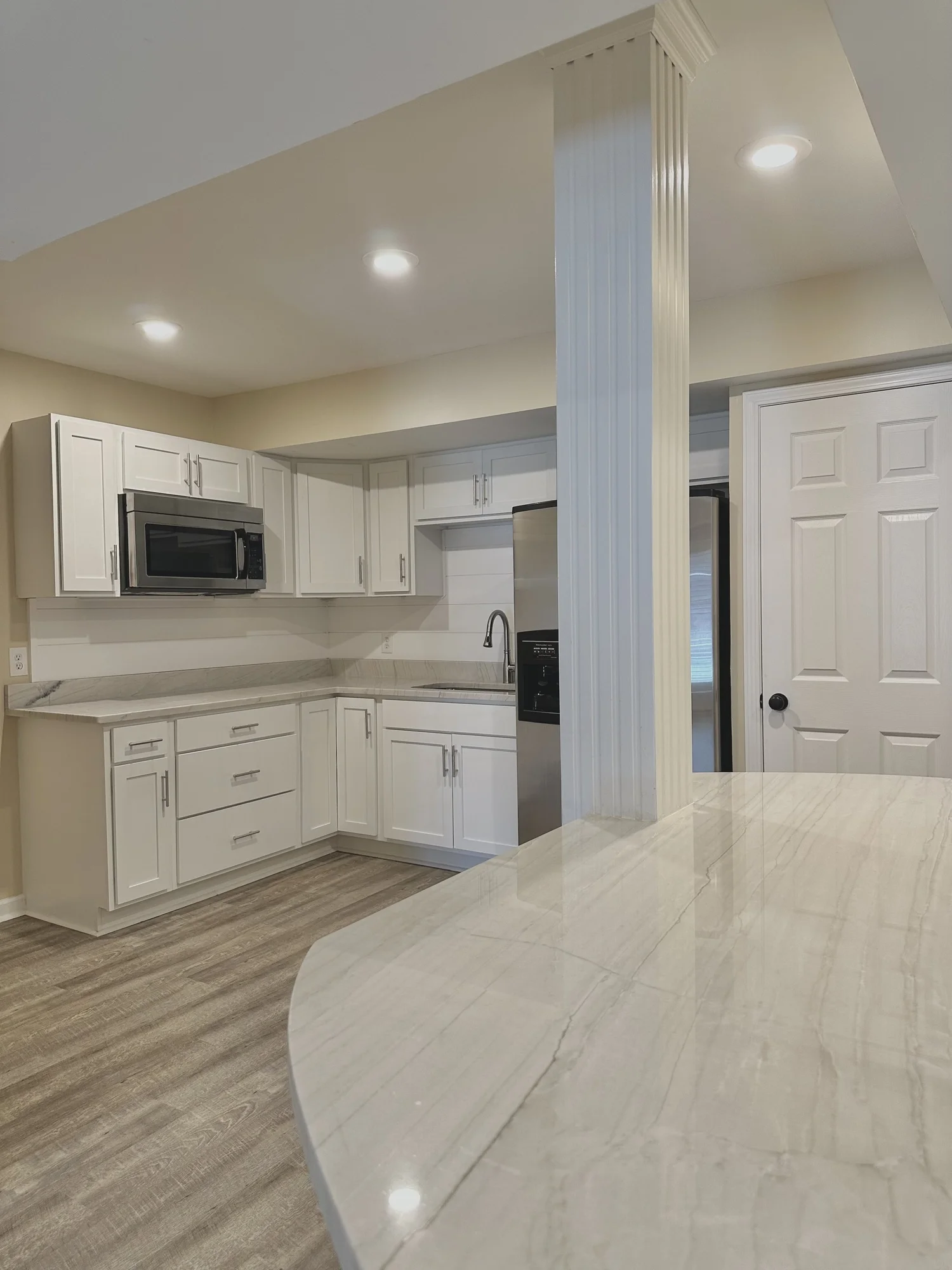 White cabinet kitchen with a light countertop installed by Sondos Stone in North Carolina