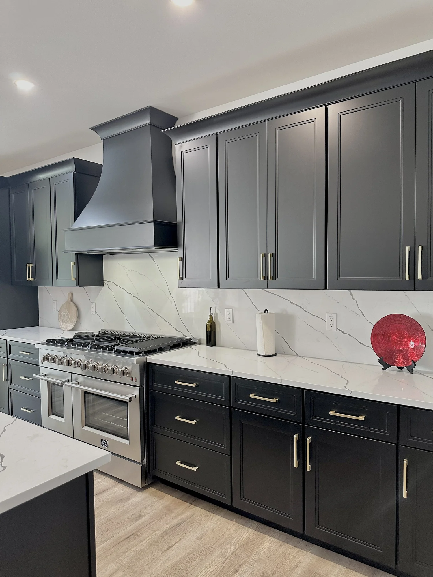 Range wall with dark cabinets and a full-height veined stone backsplash