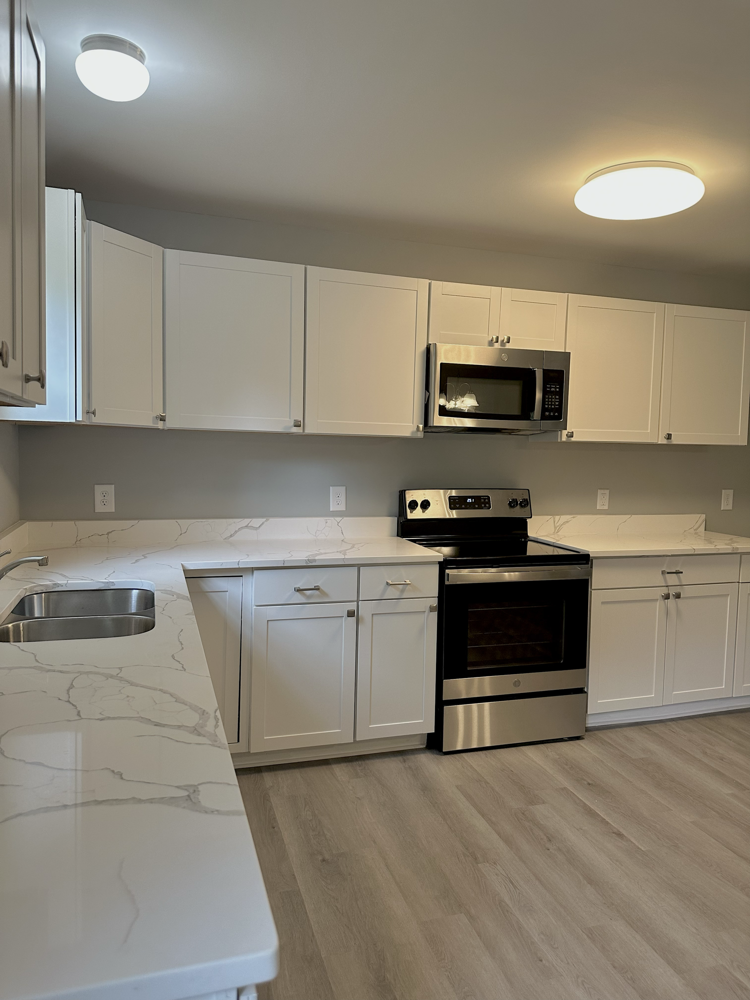Completed Sondos Stone kitchen with white cabinets and lightly patterned countertops