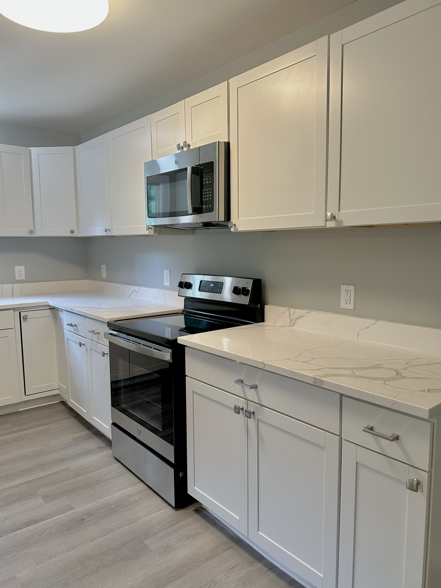 Range-side view of white veined countertops and a short matching backsplash in a Sondos Stone kitchen