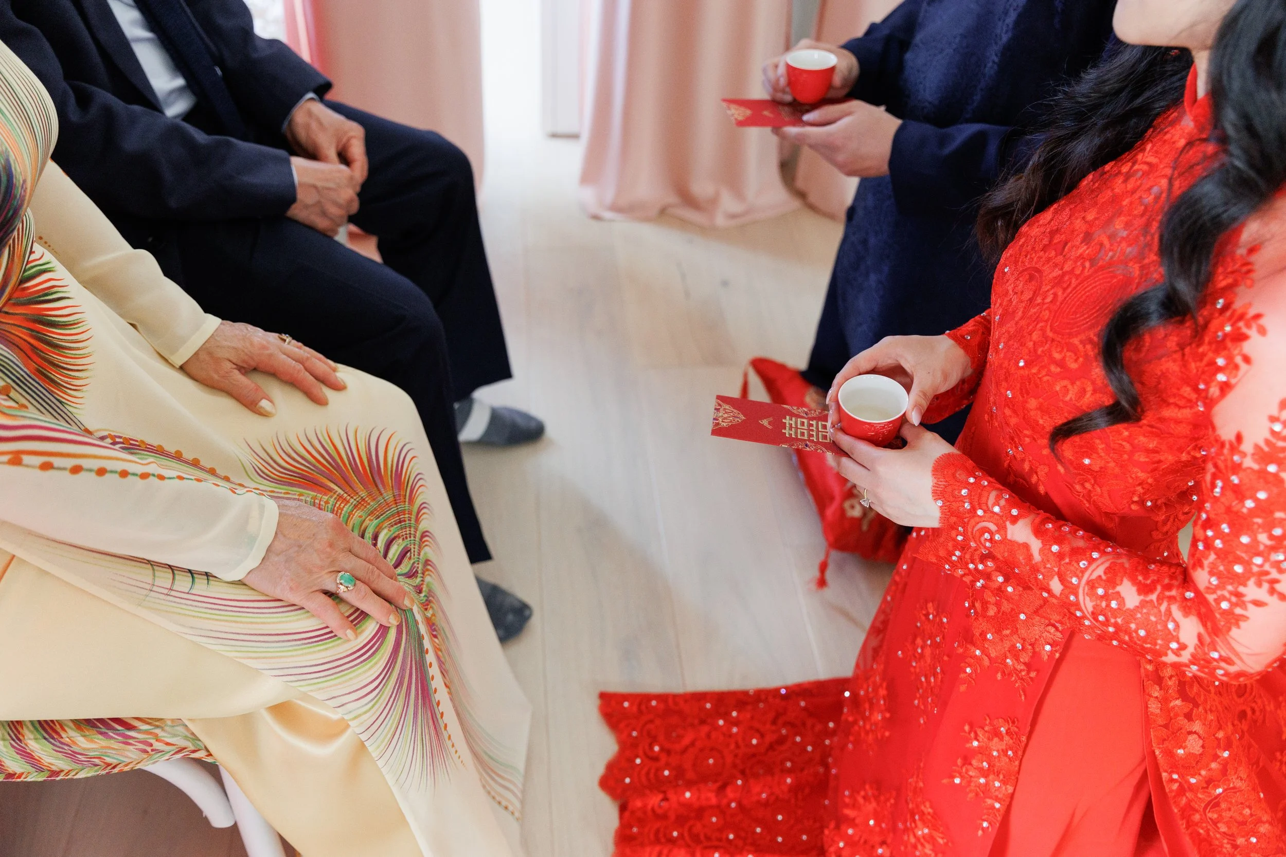 Close-up of a Vietnamese tea ceremony, with tea being served to seated guests.