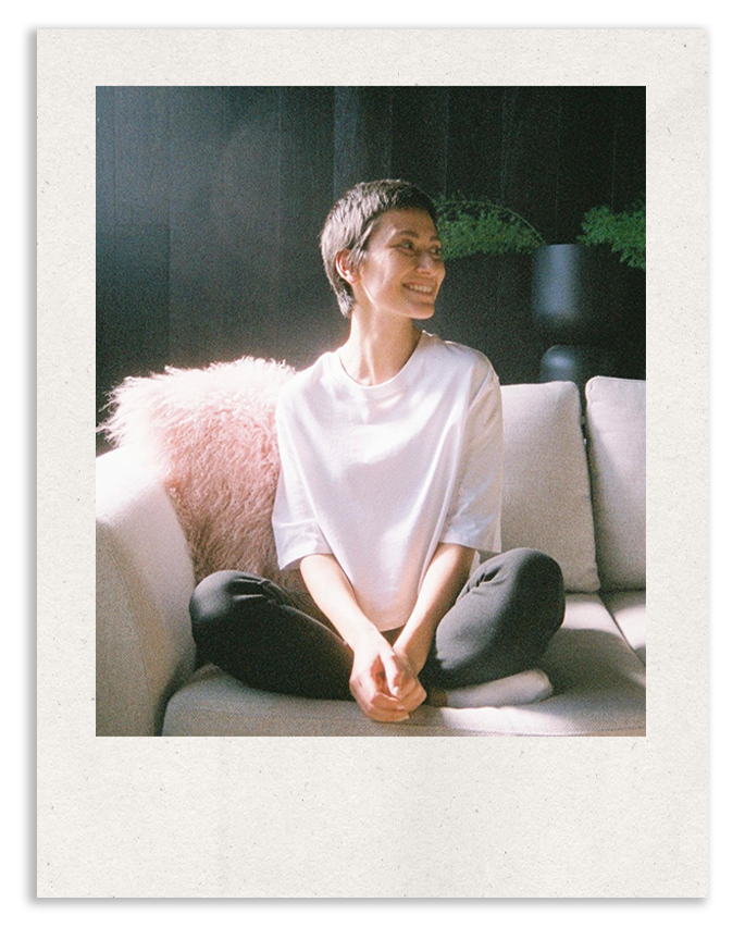 Dani, founder of Folkstone and Co, smiling while sitting on a couch at The Studio Melbourne in Moorabbin.