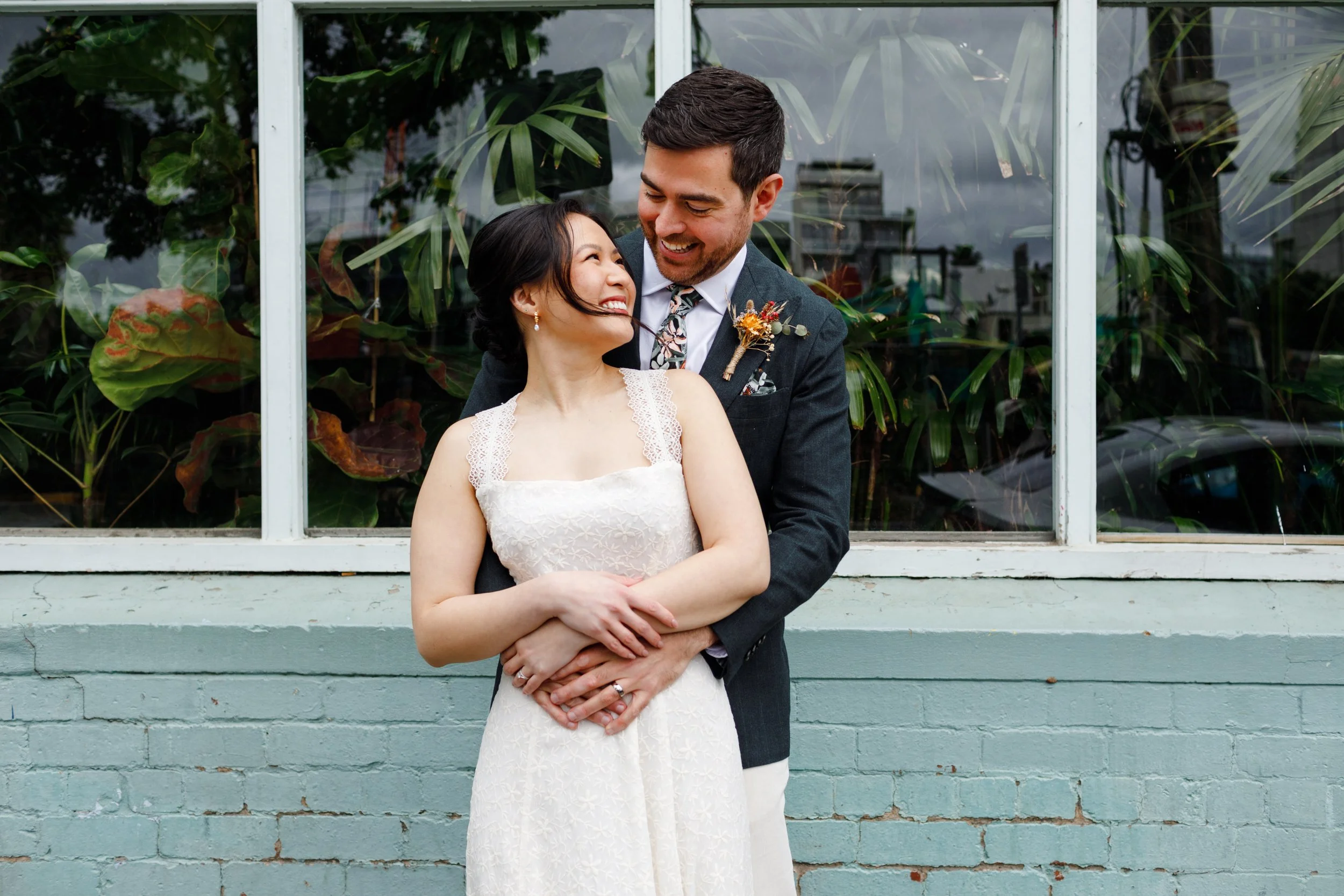 Julia and James embracing outside Glasshaus Richmond, smiling lovingly at each other on their wedding day