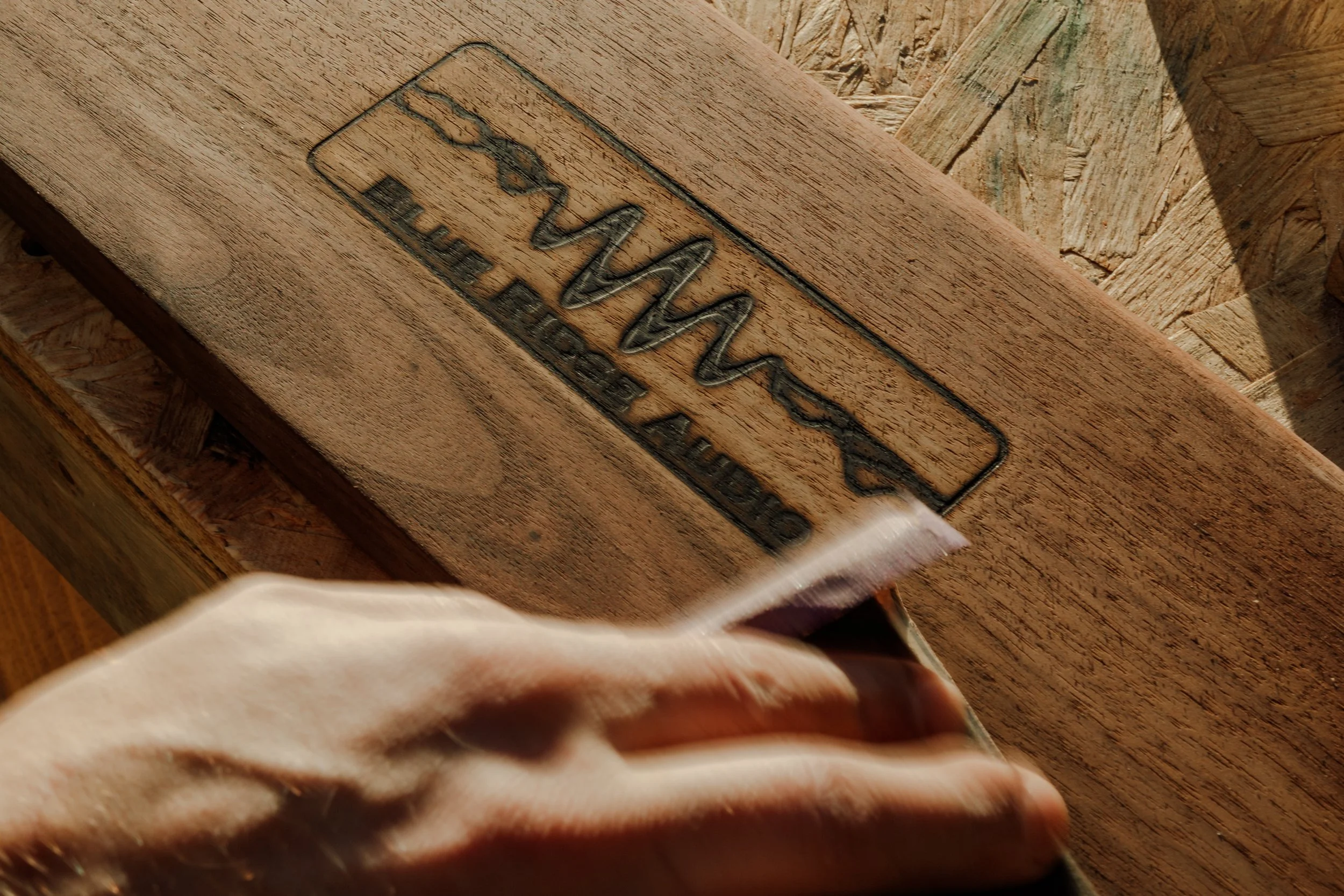 Blue Ridge Audio wood-burned logo being sanded