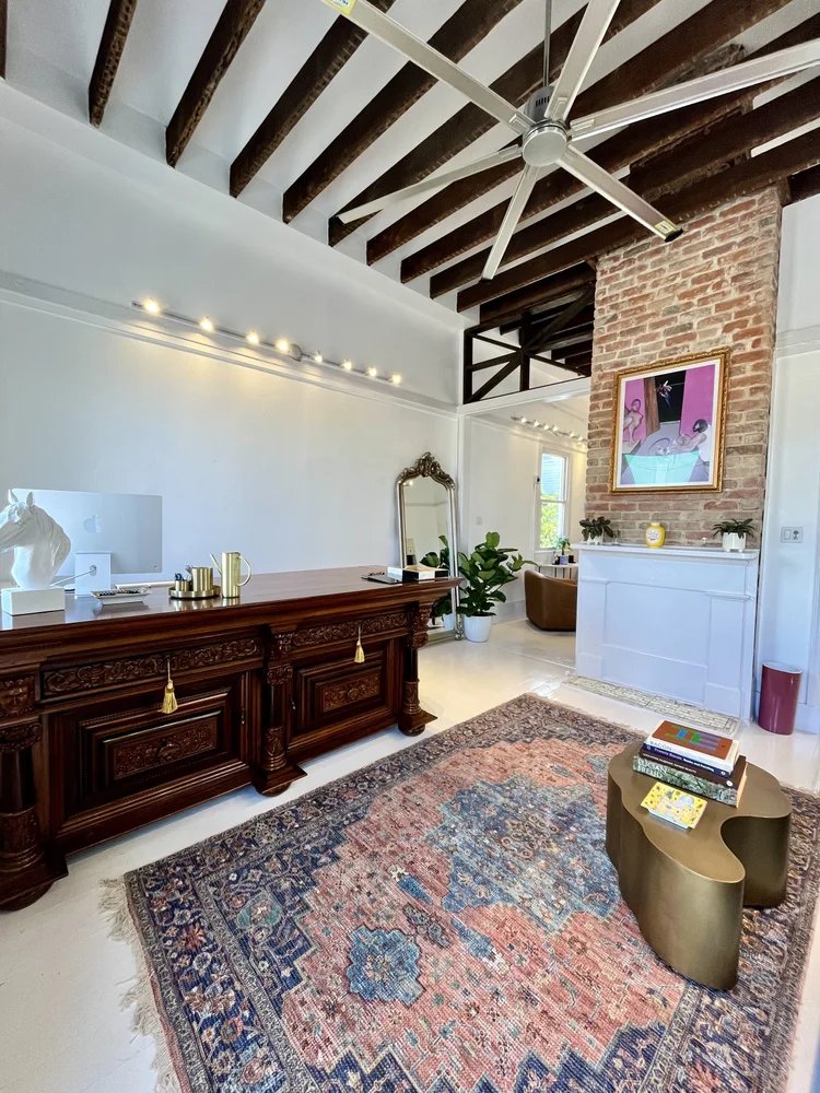 Front room with antique desk and exposed brick