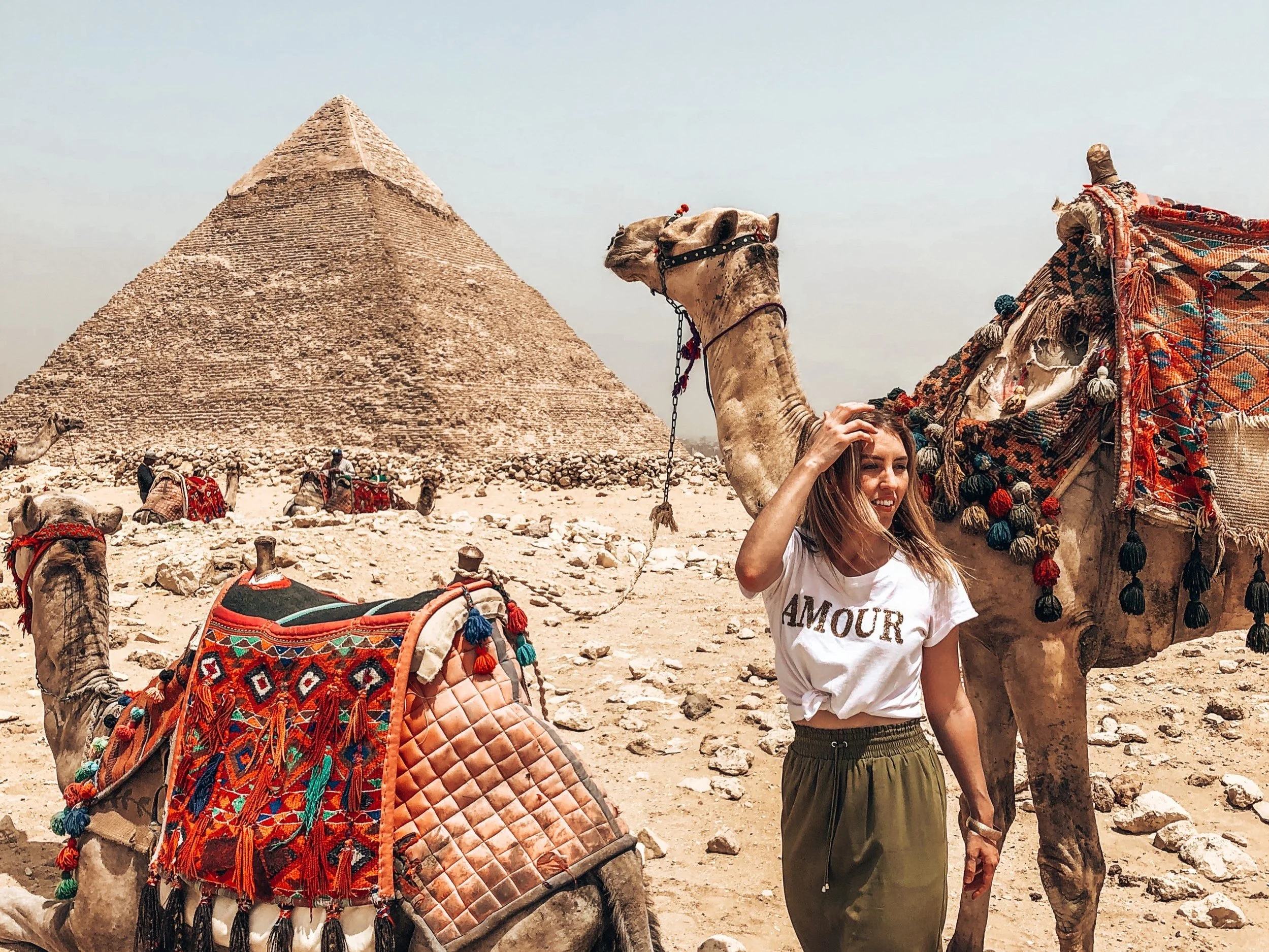 Standing in front of the Pyramids of Giza in Egypt with camels