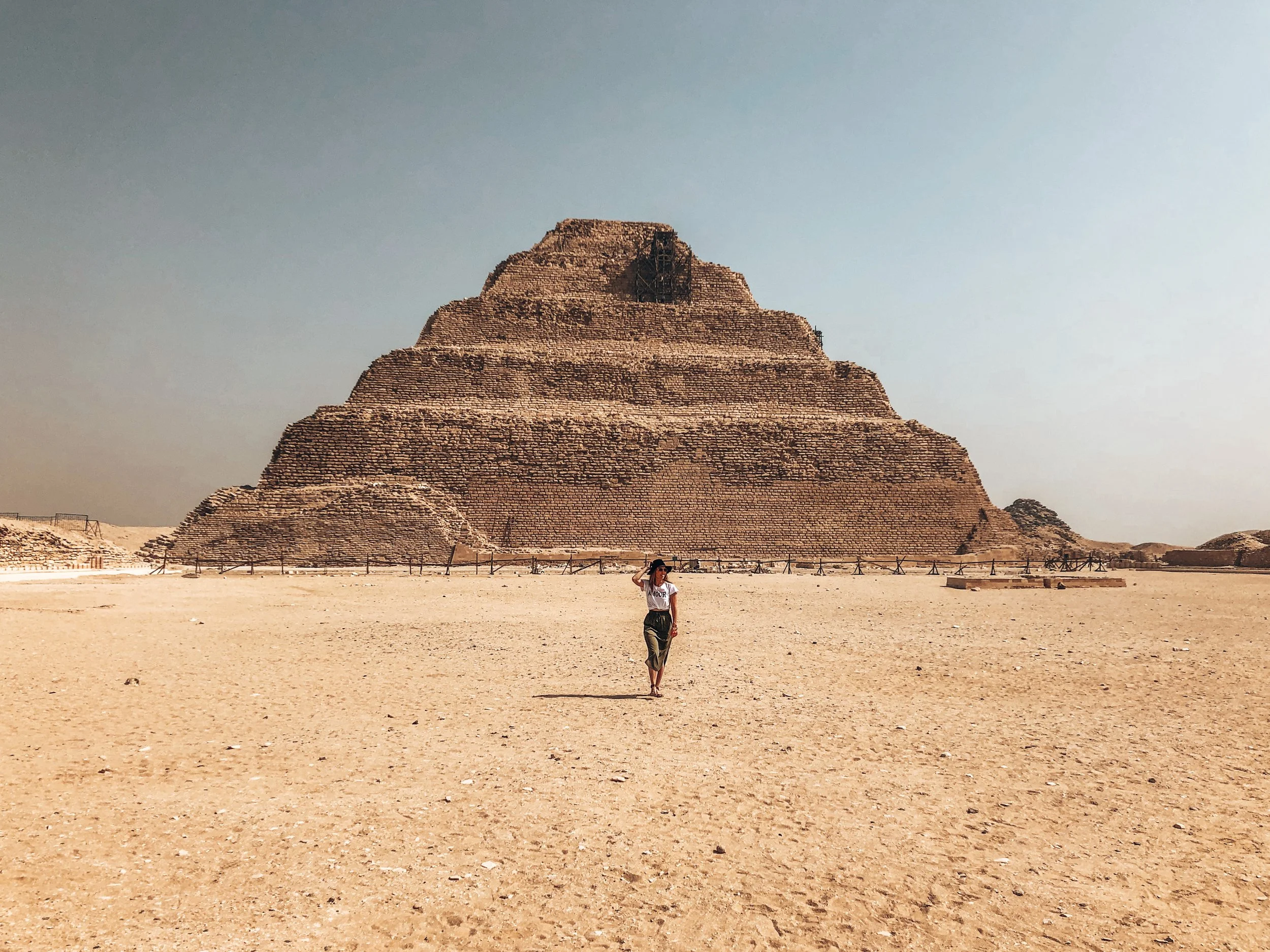Standing in front of a tiered pyramid in Egypt