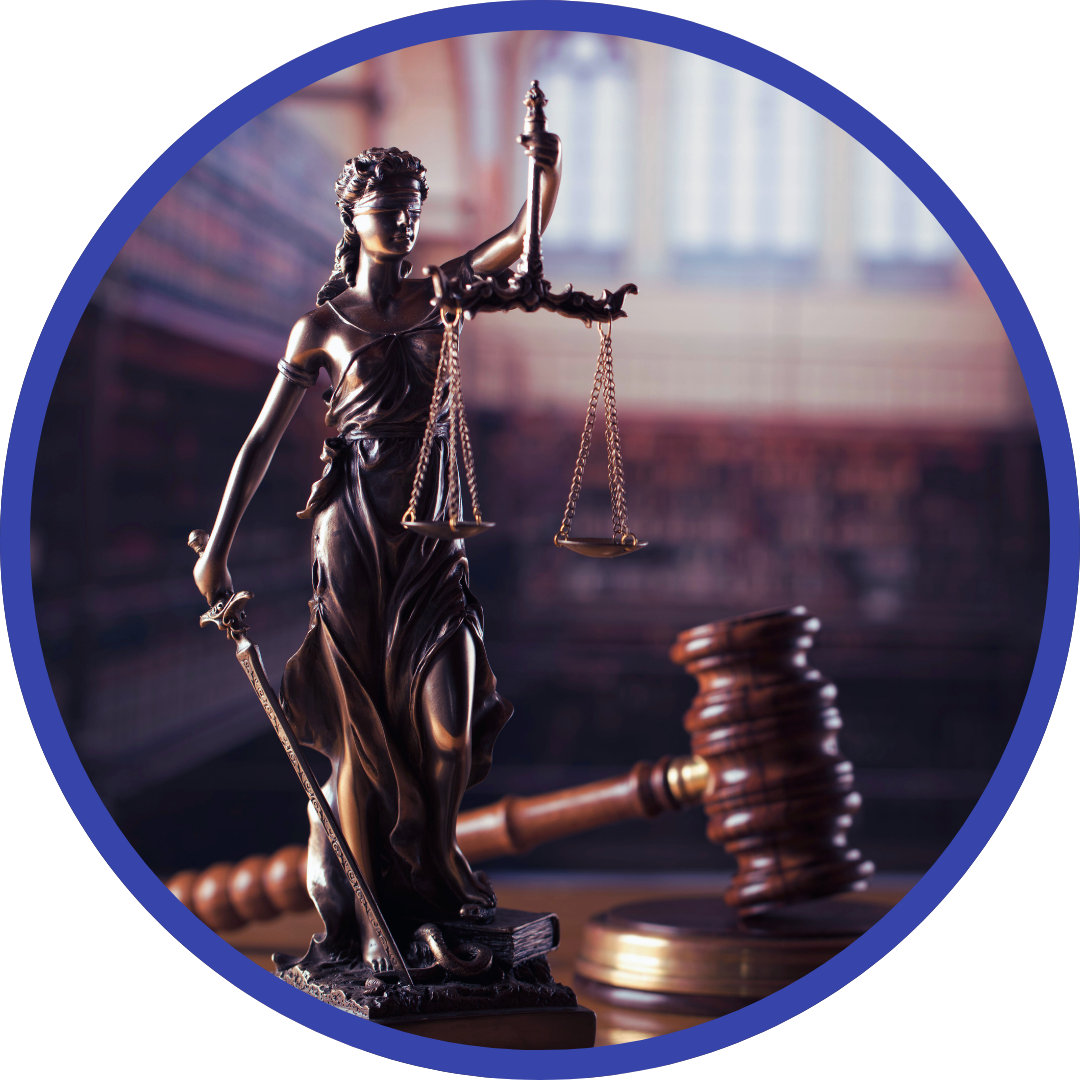 Statue of Lady Justice with scales and gavel in a courtroom setting.