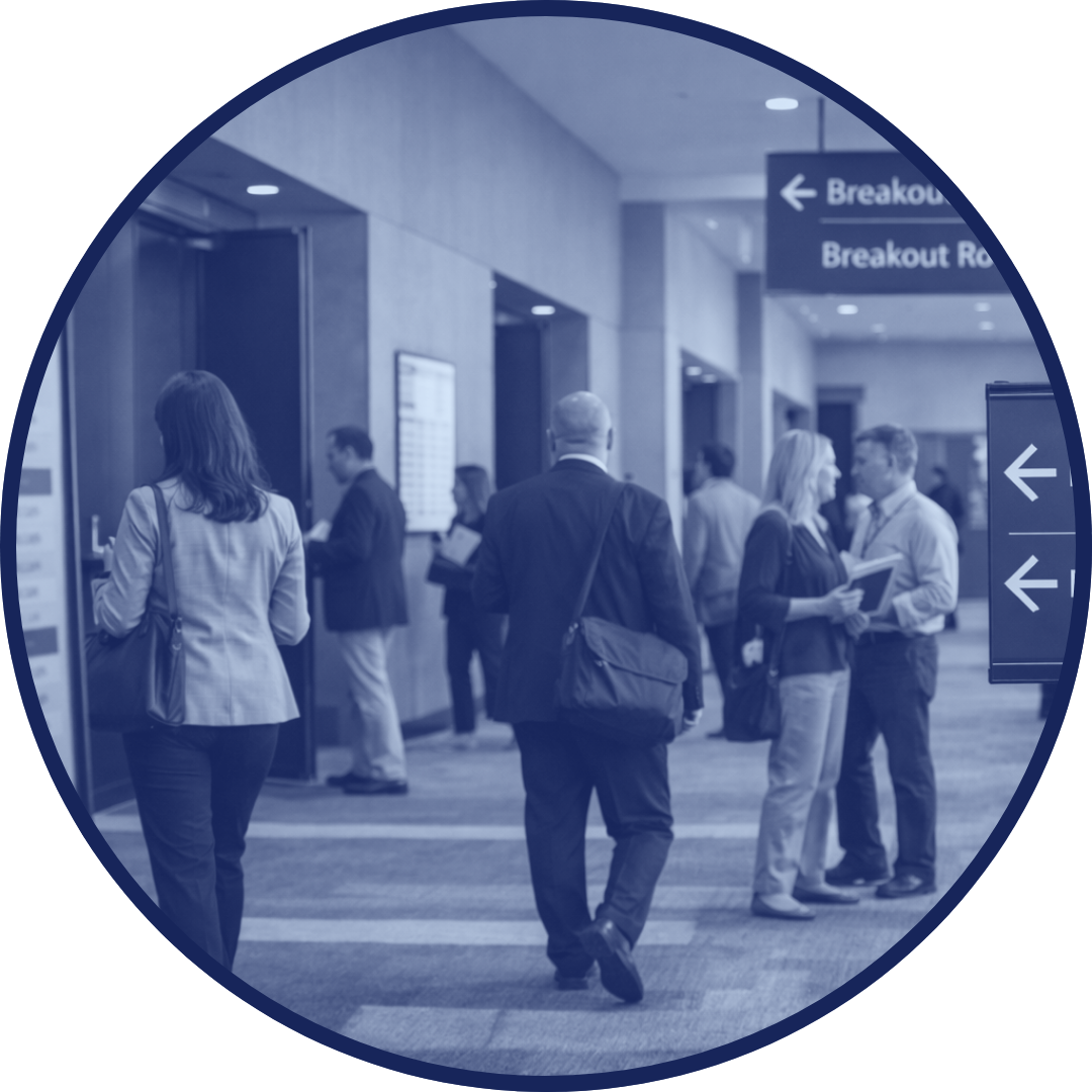 Attendees moving between breakout rooms at a professional conference venue.