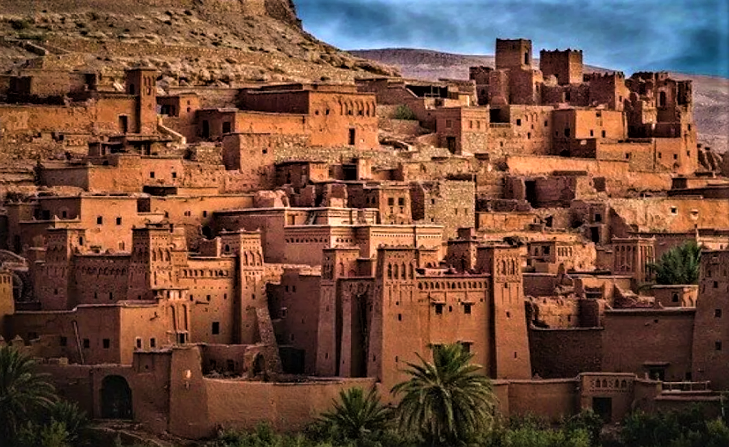 Ancient clay buildings in Ait Benhaddou, Morocco, with surrounding arid landscape.