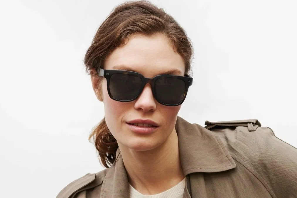 Woman wearing sunglasses and a trench coat