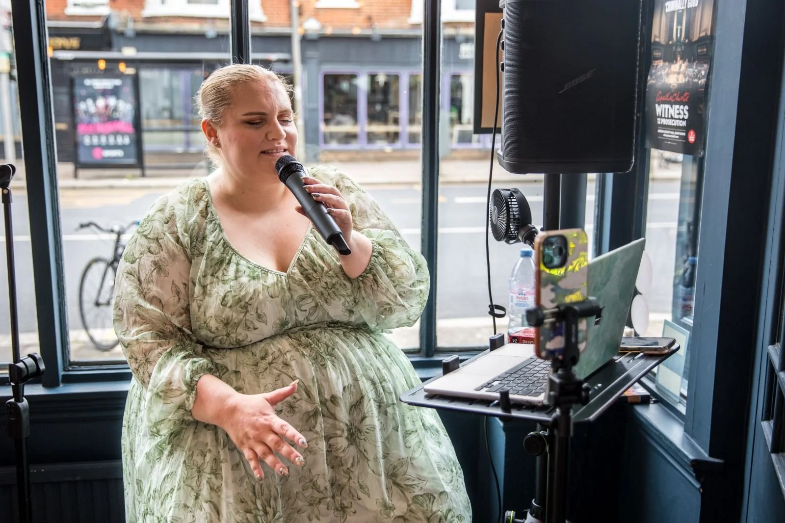 Emma Katherine Singer, in a green dress, singing during a wedding breakfast
