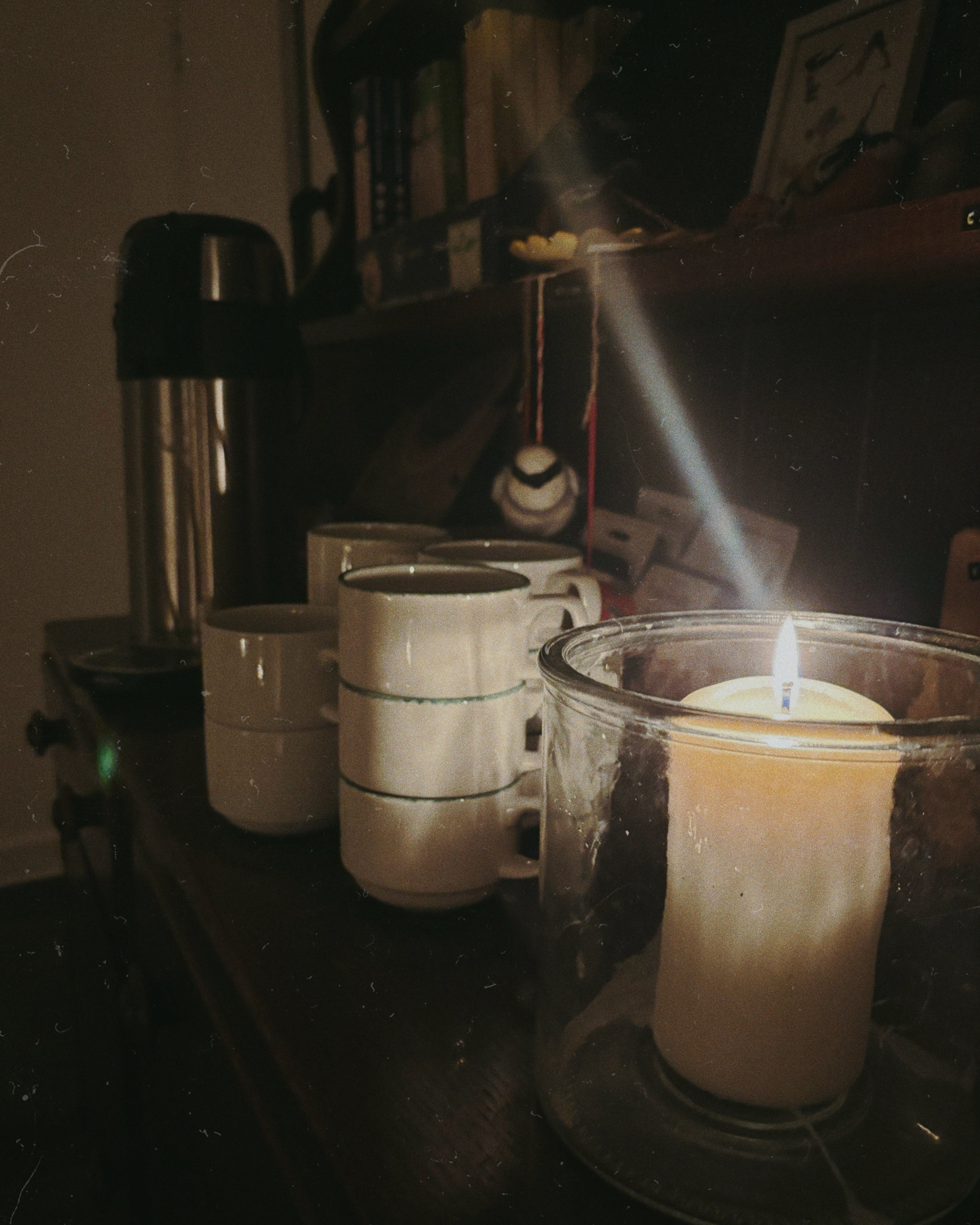 Candlelit counter with mugs, thermos, and yoga merchandise.