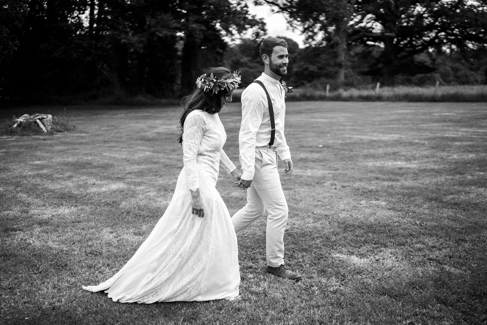 Bride and groom walk holding hands at Wasing Park in Reading