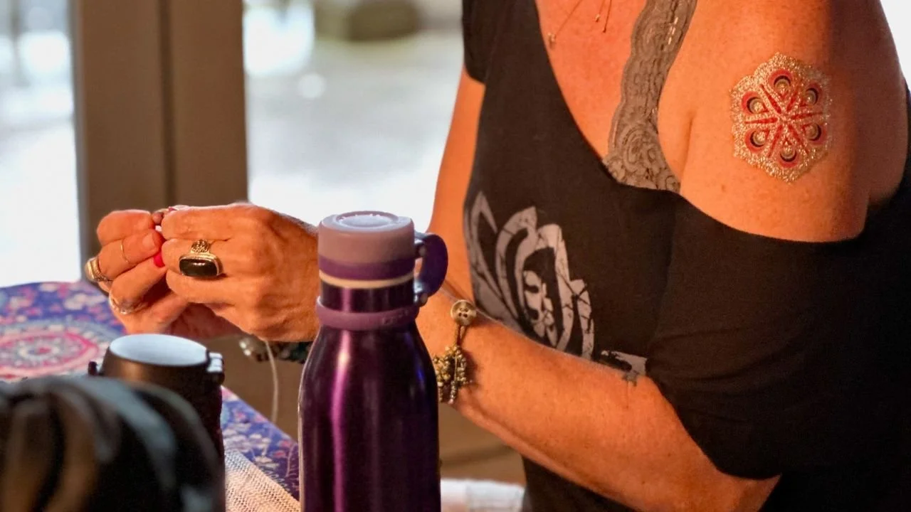 Hands organizing meaningful objects to represent love, care, and supportive systems in a heart-centered business