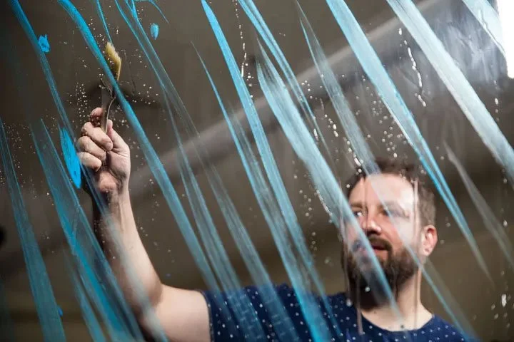 Peter Durand applies water to a wall.