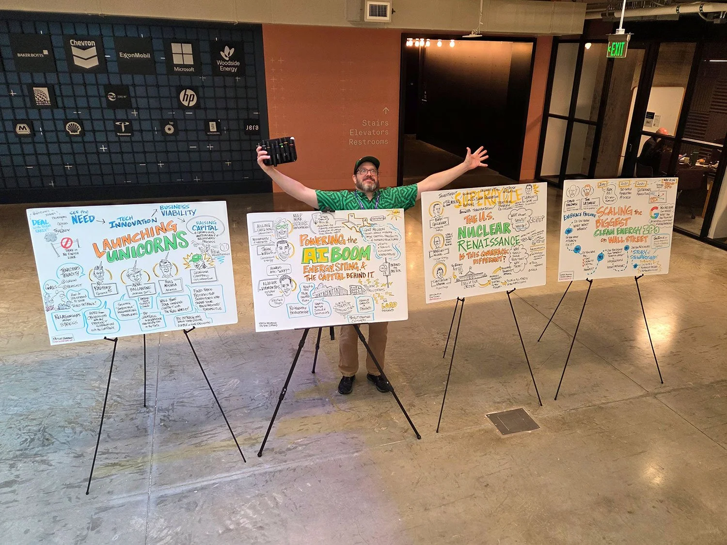 Peter Durand poses with arms wide and markers in his hands behind graphic recording from the 2026 Climatetech Summit.