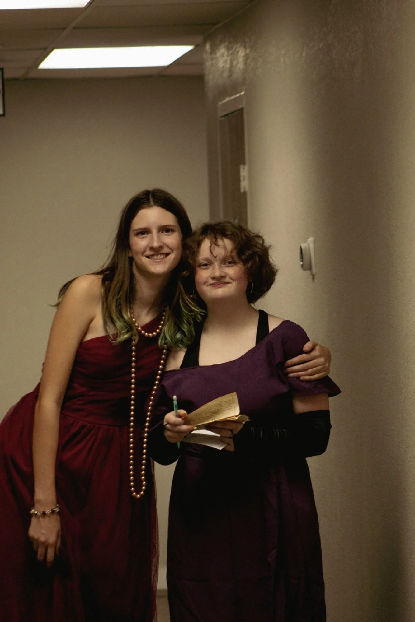 Two students in costume holding clue notes at the Clue-themed Late Night