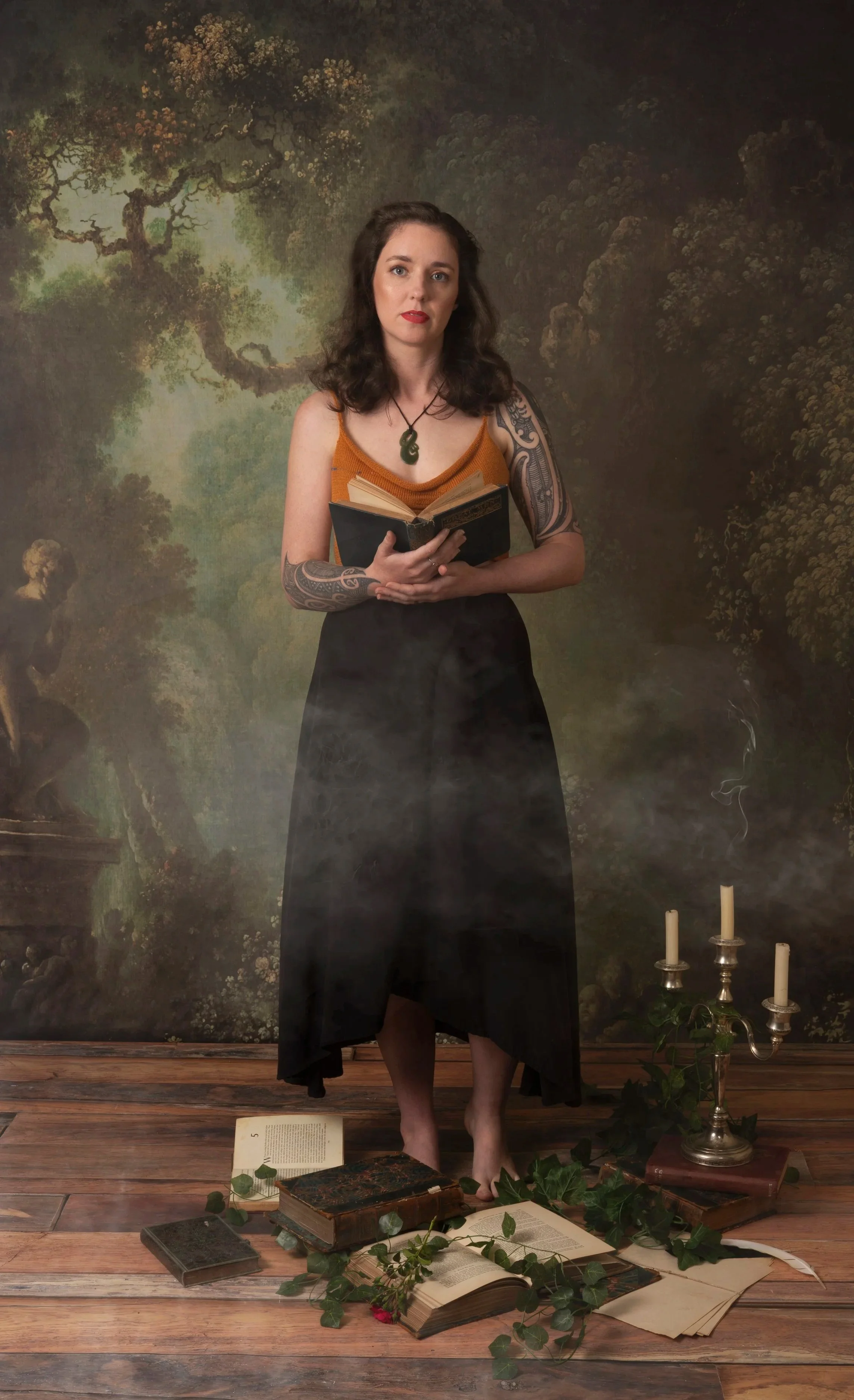 A portrait of L. M. Woodward. She stands with an open book in her hands, smoke billowing around her.