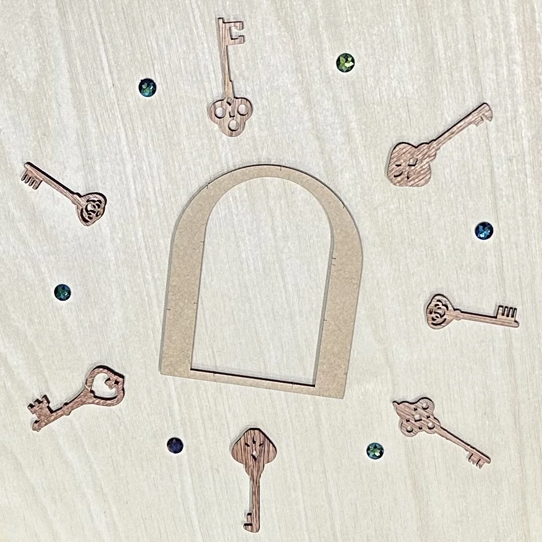 A collection of antique keys arranged around a wooden door, suggesting possibilities.