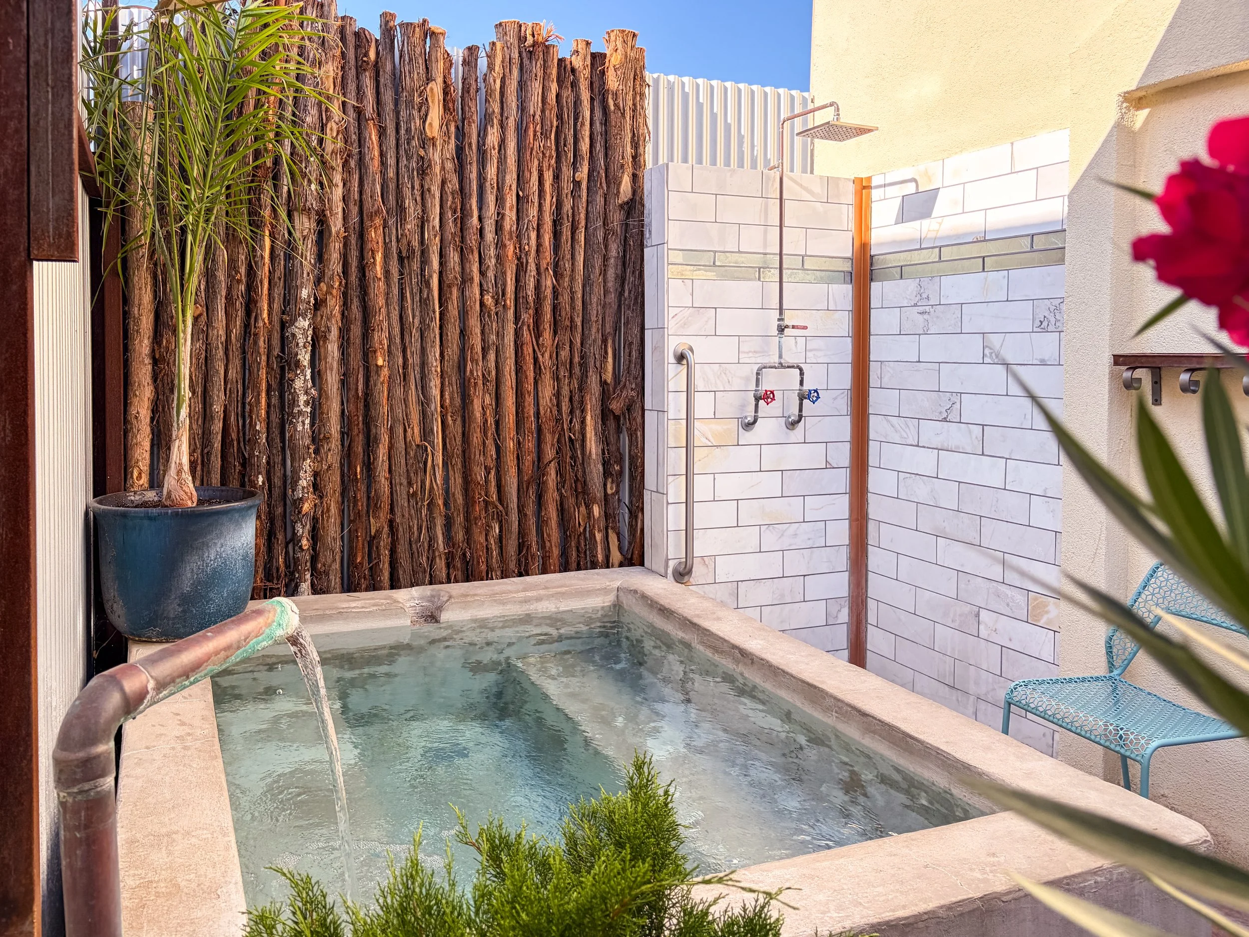 Photo of the Cedar Pool during daytime with water flowing from a copper spout