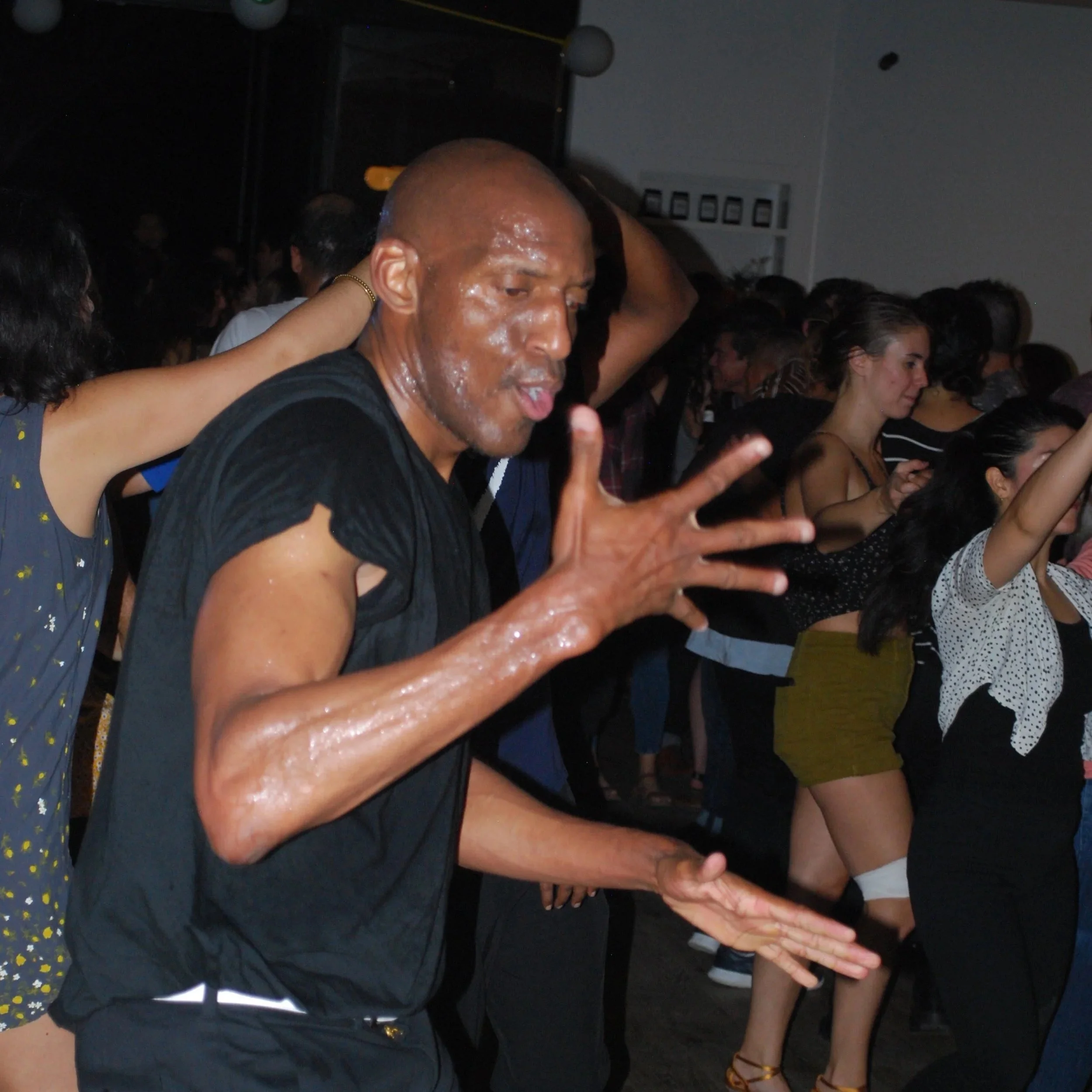 Person dancing and enjoying music at a crowded party or club, with other people dancing in the background. Austin, TX