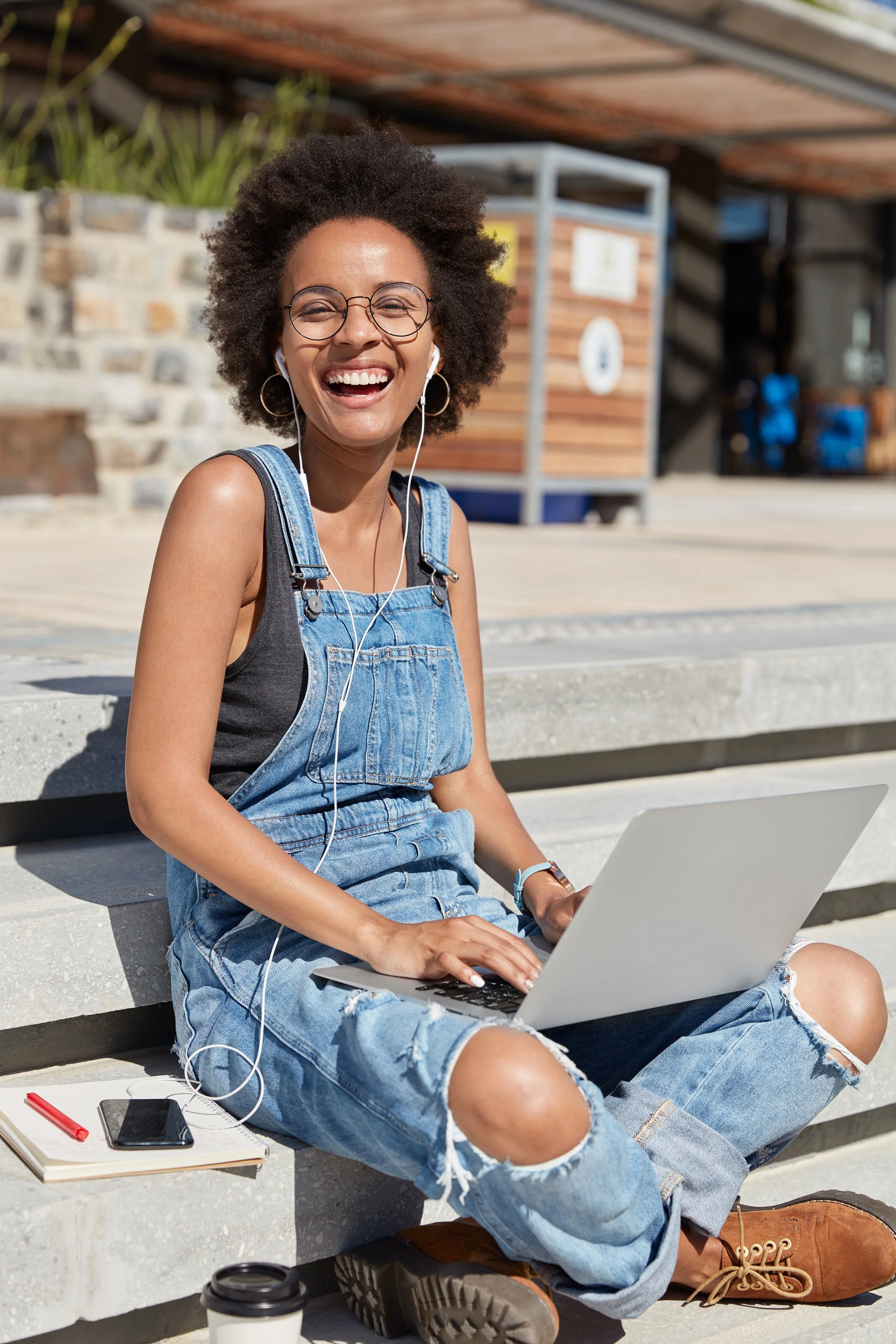Smiling architecture student working on her laptop outdoors