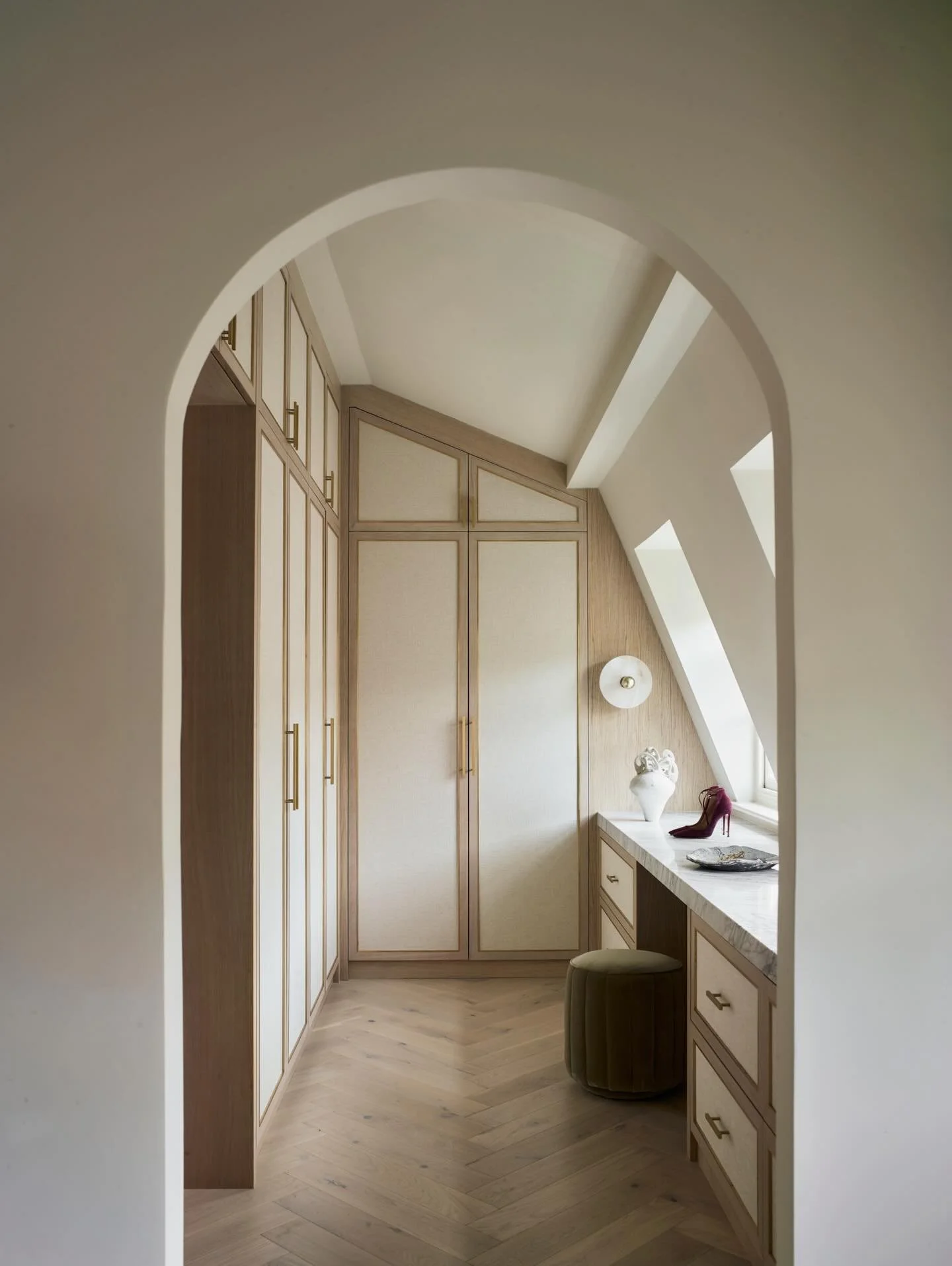 The dressing room in our Chelsea Arches mews house - we designed bespoke fabric inlay with brass trim doors and tailored the internal storage exactly to our clients needs. You enter the principal bedroom suite through the dressing room, an arched ope