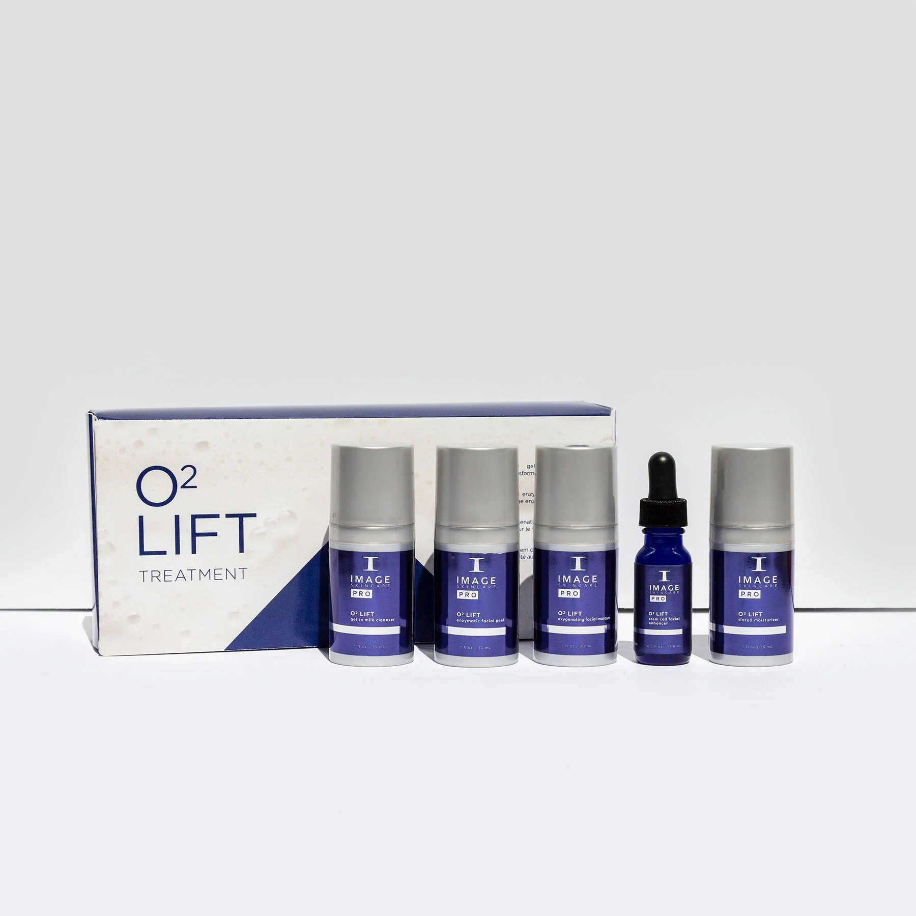 Set of skincare products including five bottles and a box labeled 'O2 Lift Treatment' with various skincare labels, arranged in a line against a white background.