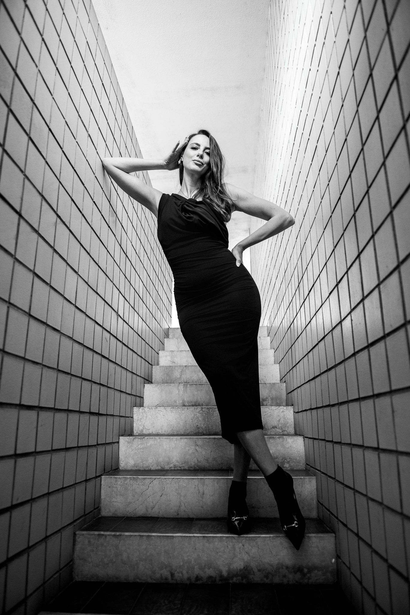 Ritratto femminile con attitudine, donna in abito nero su scala — Studio Lumière, Studio Hound Portraits Milano
