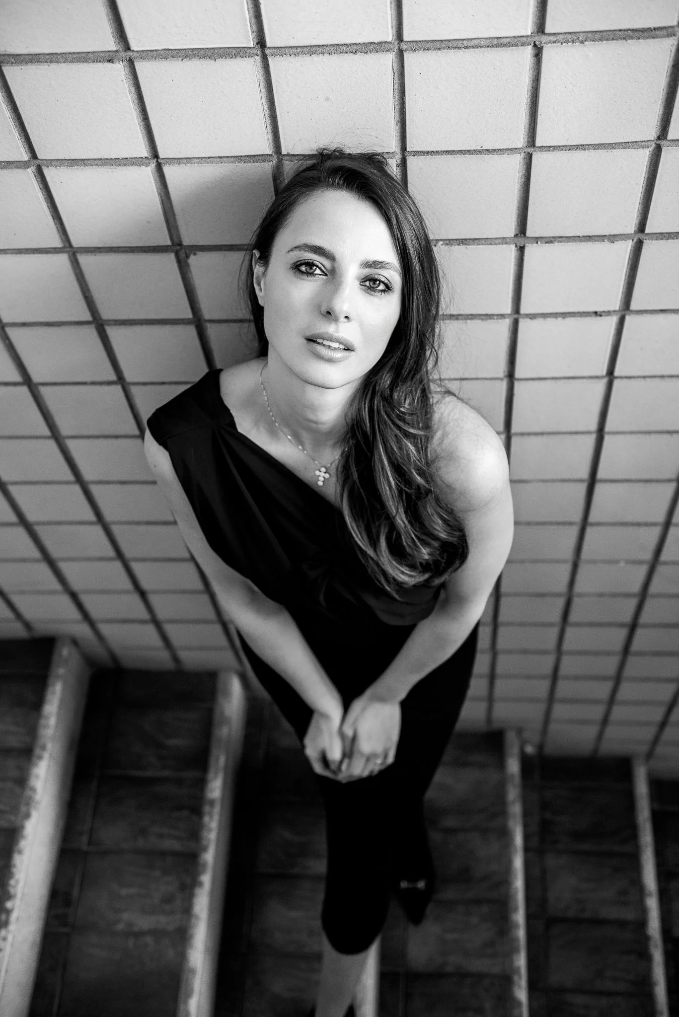 Ritratto femminile con attitudine, donna in abito nero su scala — Studio Lumière, Studio Hound Portraits Milano