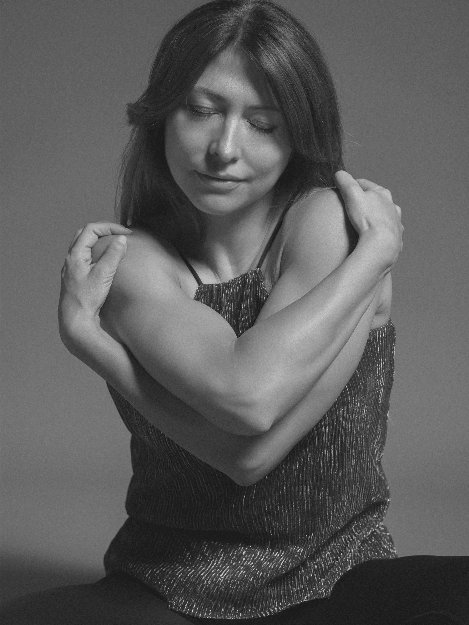 Ritratto femminile intimo in bianco e nero, donna che si abbraccia — sessione Così Come Sei, Studio Hound Portraits Milano