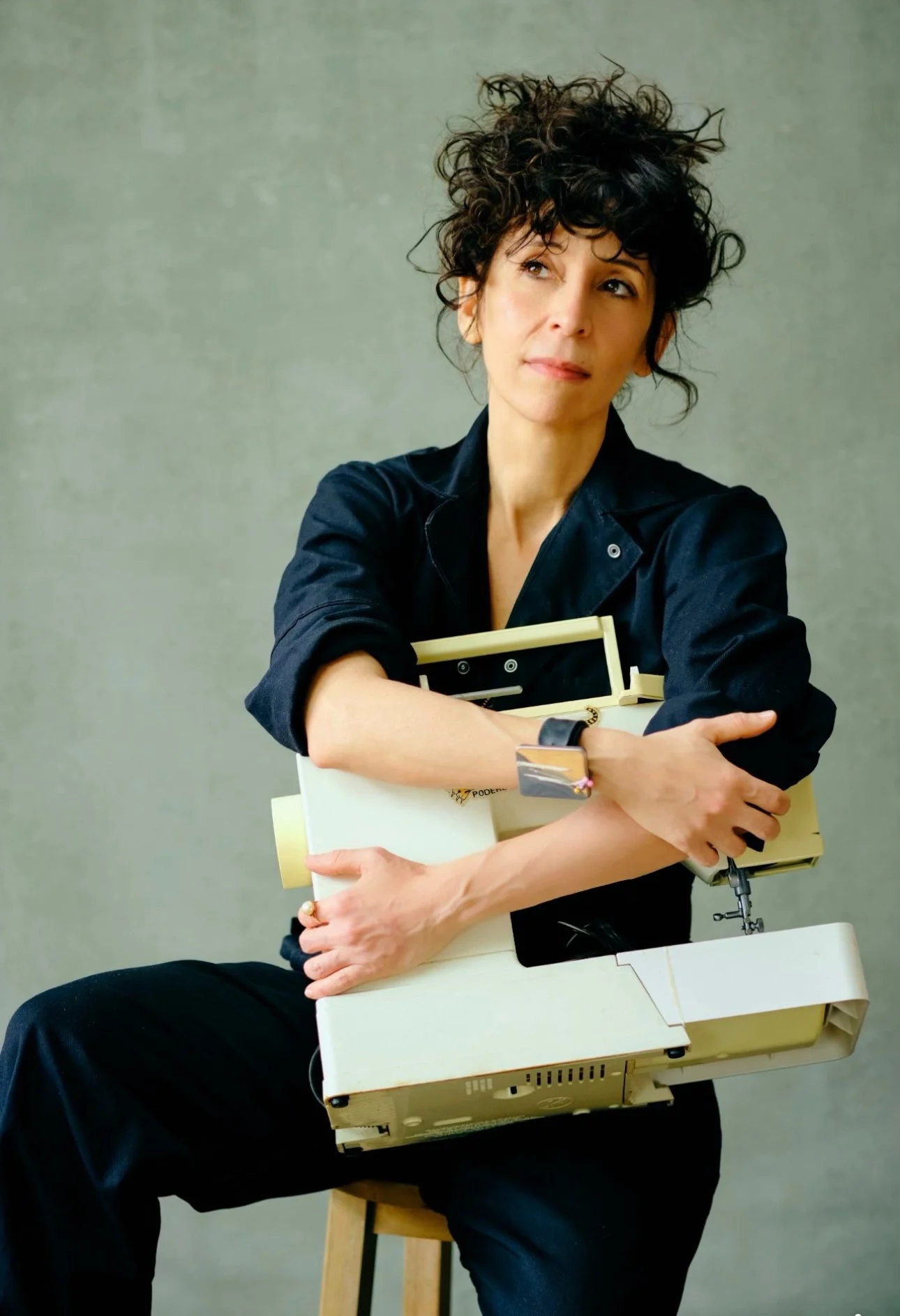 Rocio Salceda, founder and creative director posing with sewing machines