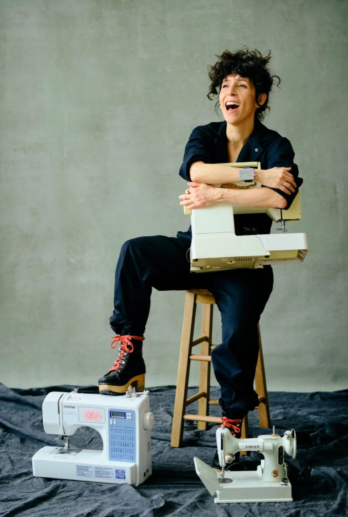 Rocio Salceda, founder and creative director posing with sewing machines