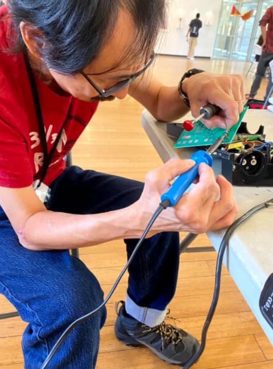 Kenneth Mah, volunteer at Repair Café El Barrio fixing a stopwatch