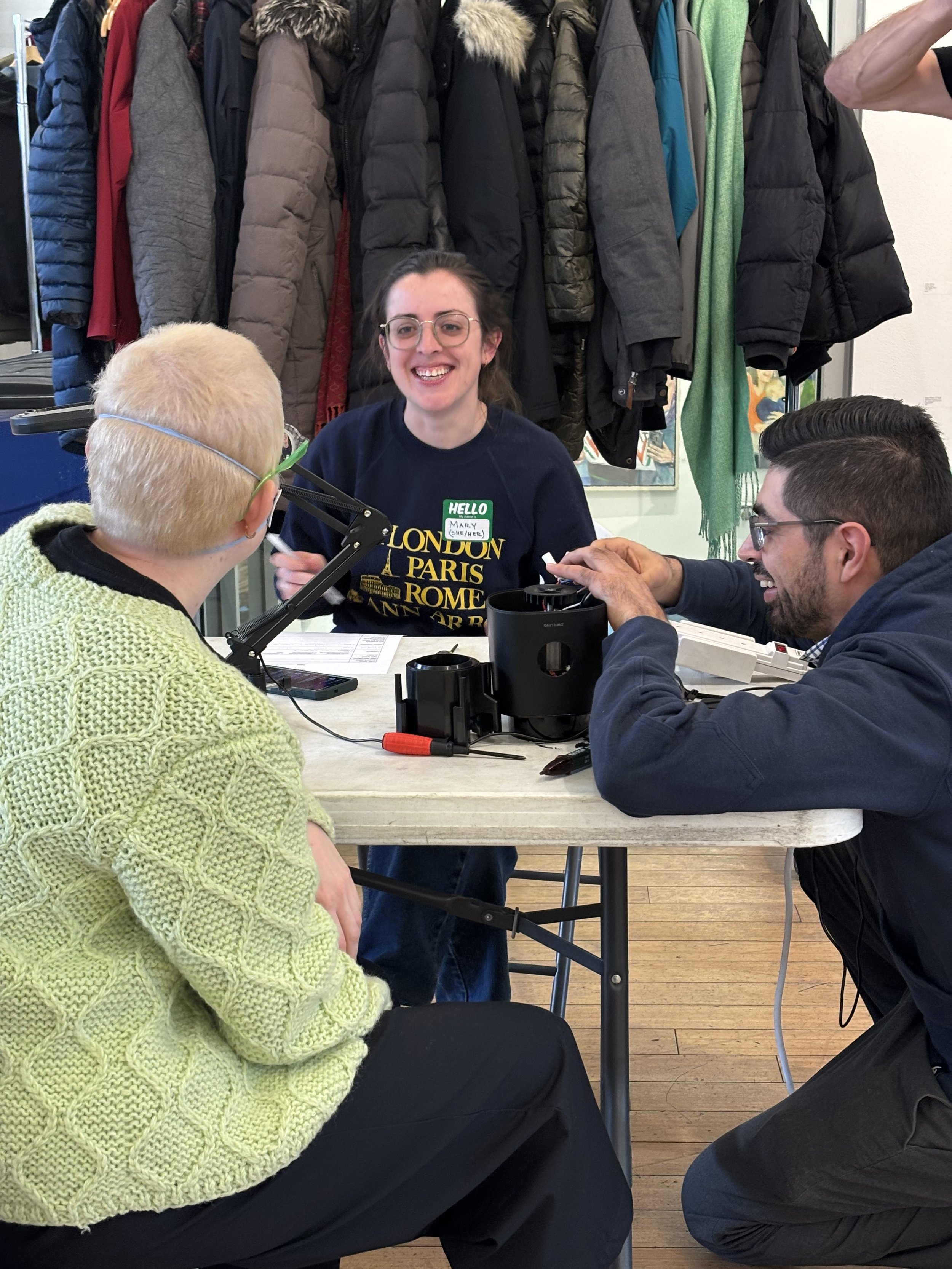 Volunteers and guests smiling and repairing at Repair Cafe El Barrio