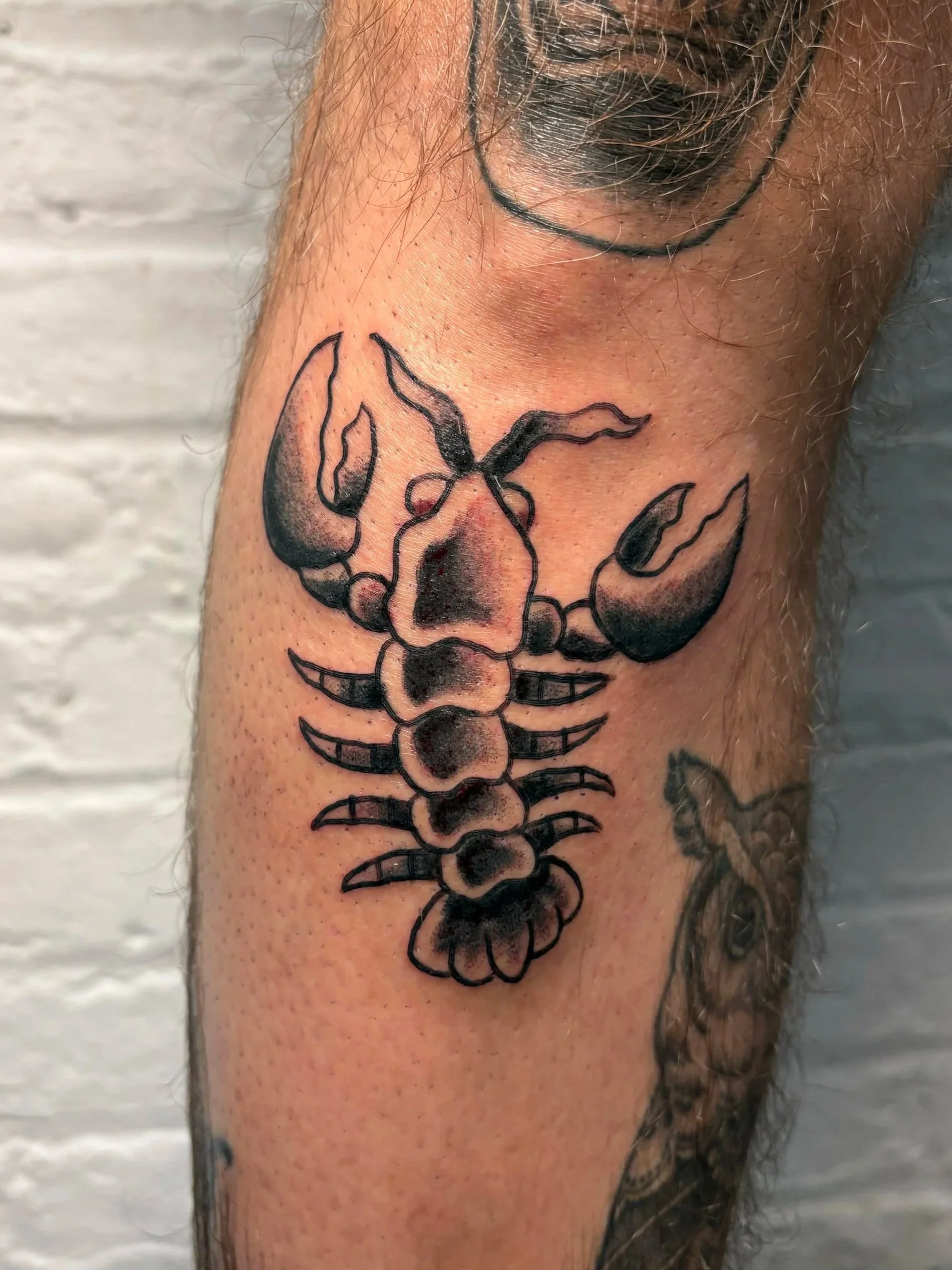 american traditional tattoo of a lobster in black and grey ink 